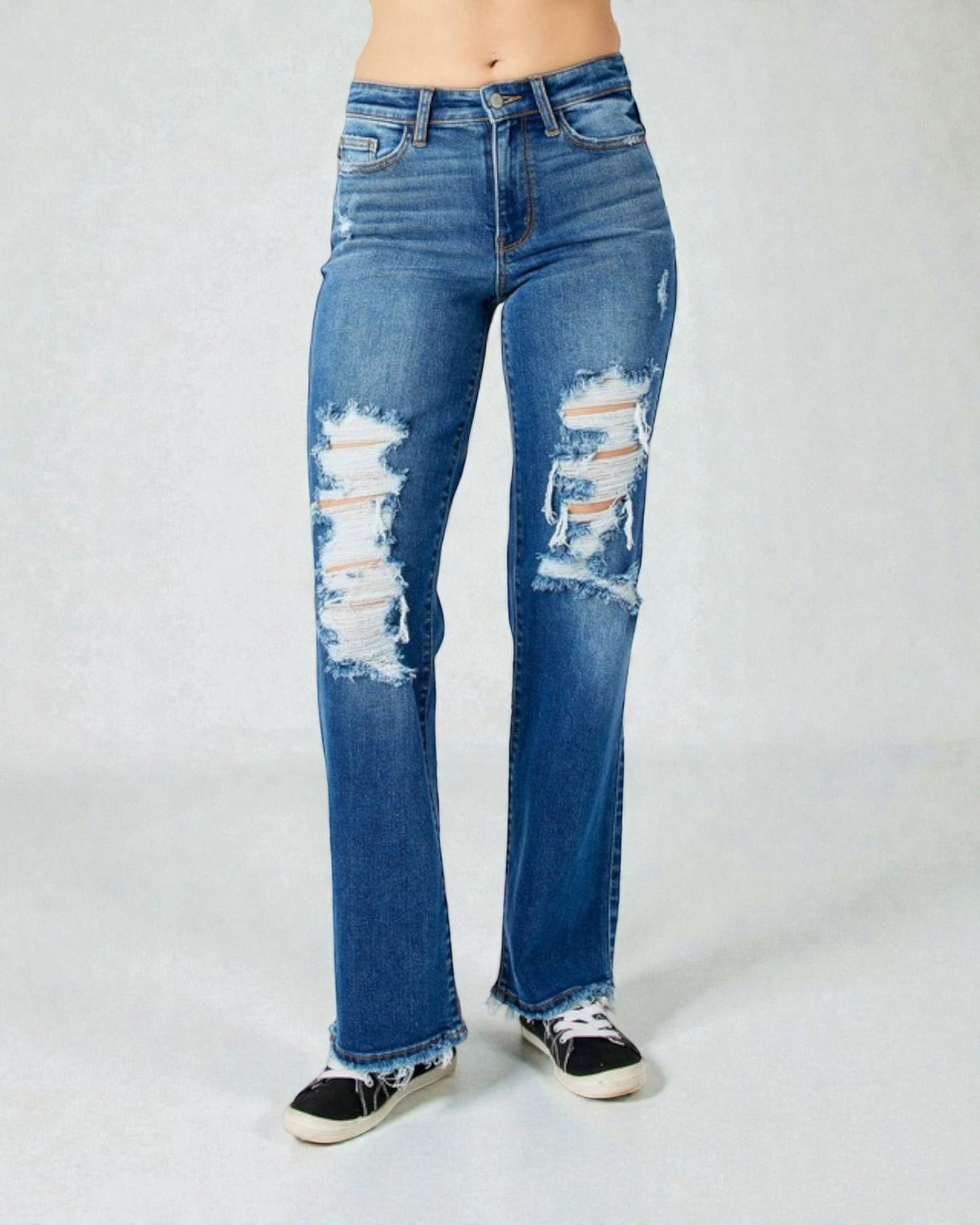 Distressed blue jeans on a plain background