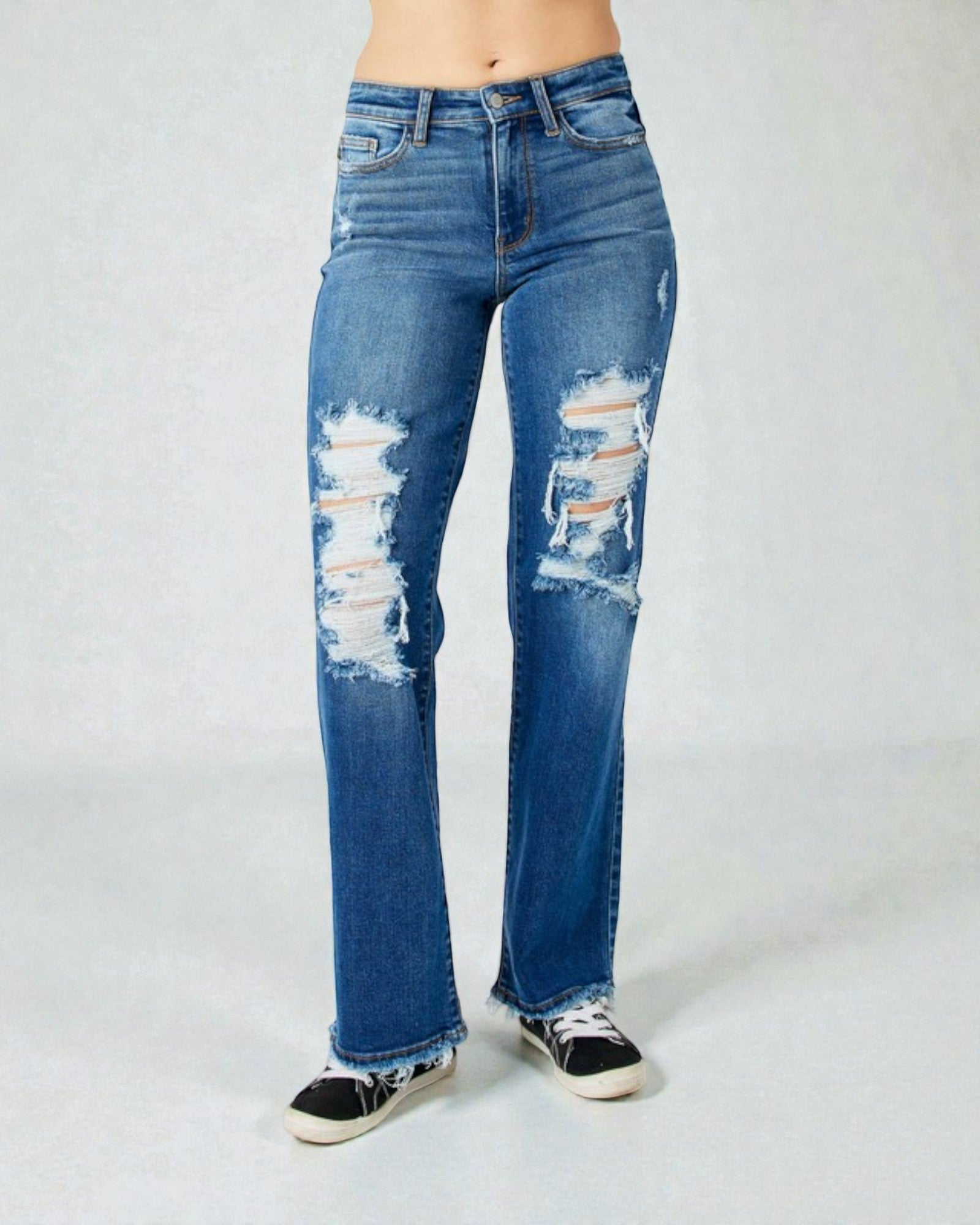 Distressed blue jeans on a plain background