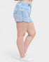 Light blue denim shorts worn by a person on a white background