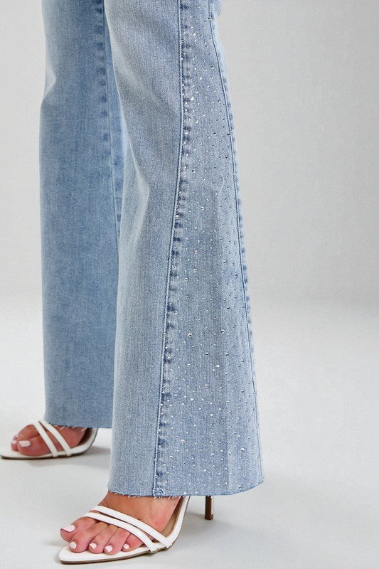 Light blue jeans with a subtle pattern worn by a person on a plain background