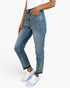 A person wearing light-to-medium wash blue denim jeans with a straight-to-ripped leg and white sneakers, shown from the waist down against a clean white studio background.