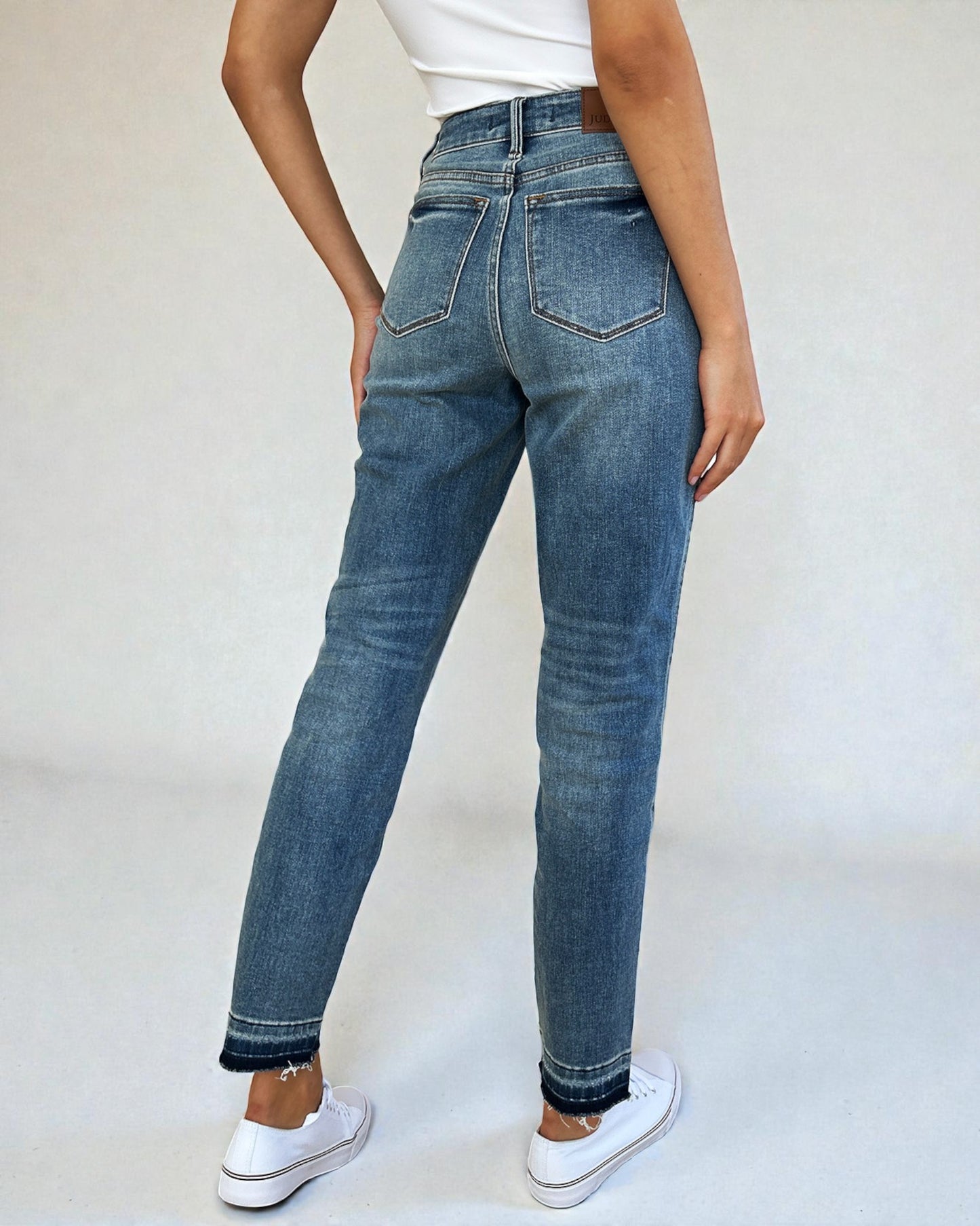 Person wearing blue jeans on a white background