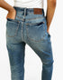 Rear view of a person wearing blue denim jeans with a brown leather patch on the back waistband that reads 'JUDY BUEY'.