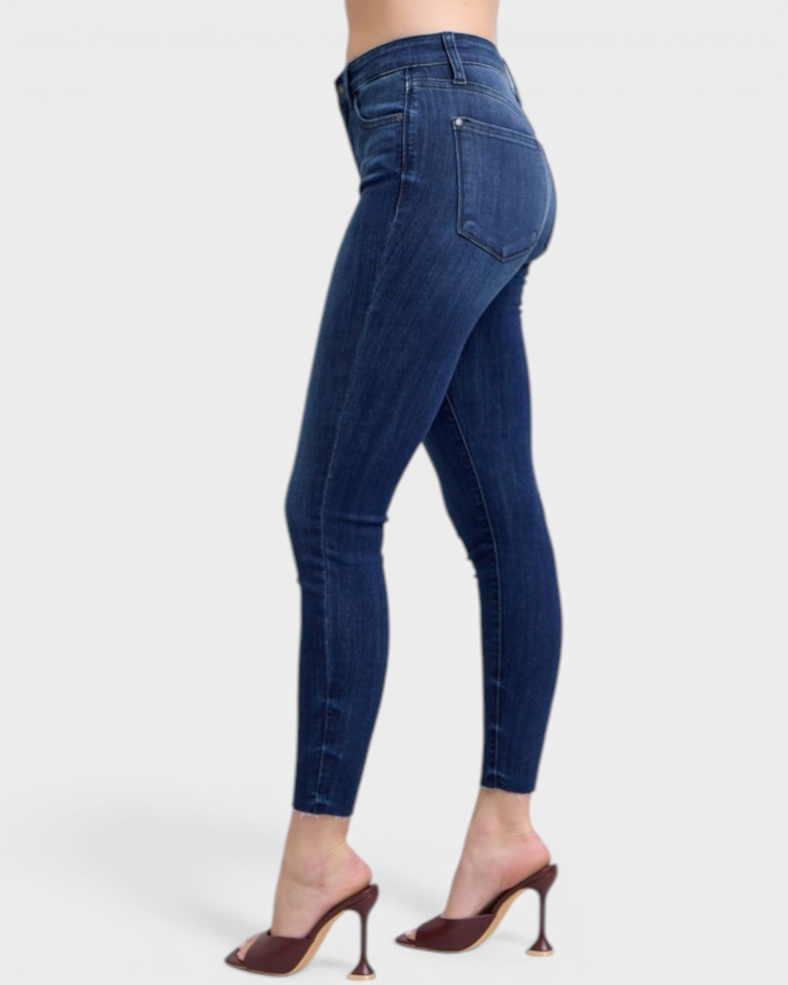 Blue jeans worn by a person on a white background