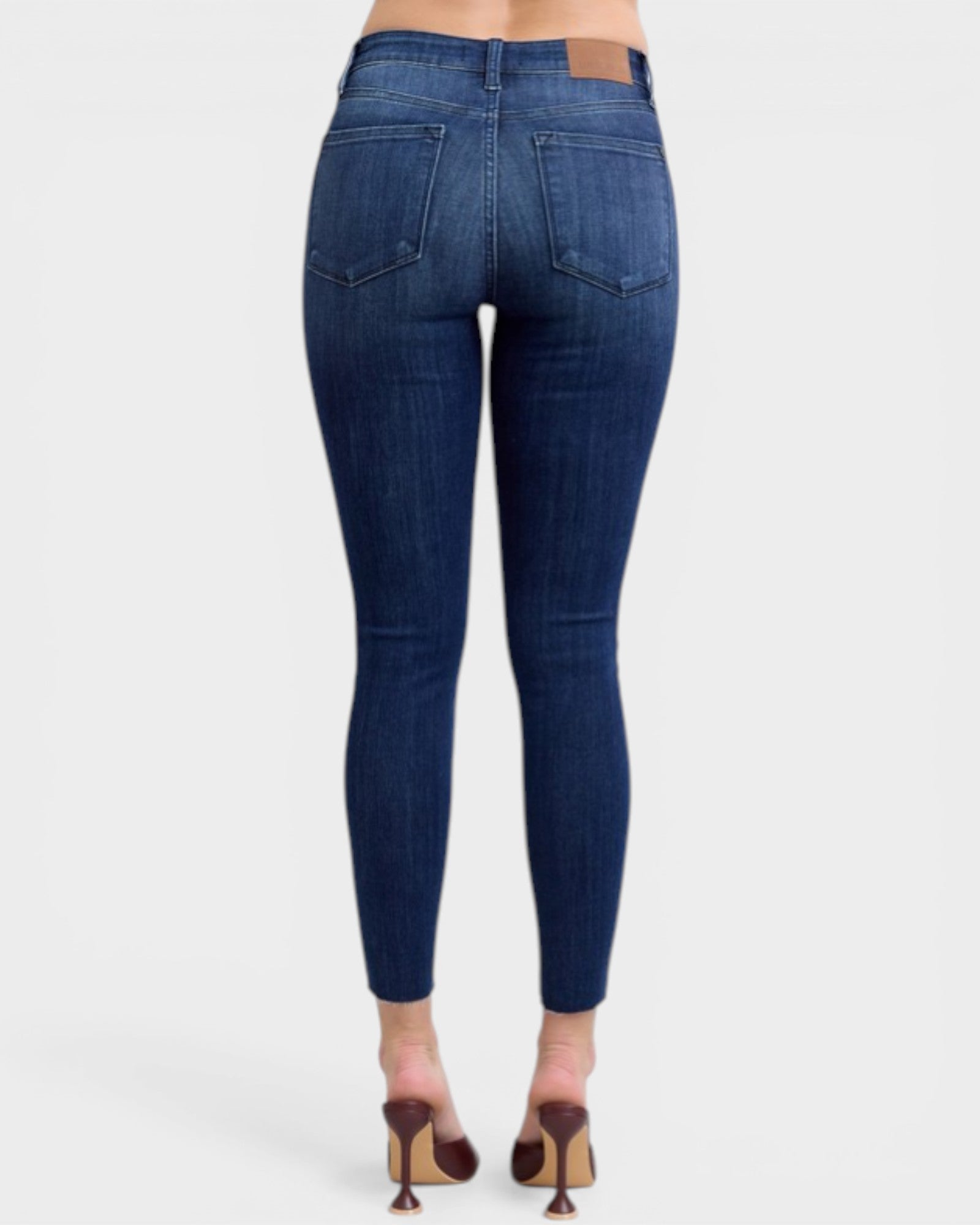 Blue jeans worn by a person on a white background