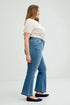 Woman wearing blue jeans and a white top on a white background
