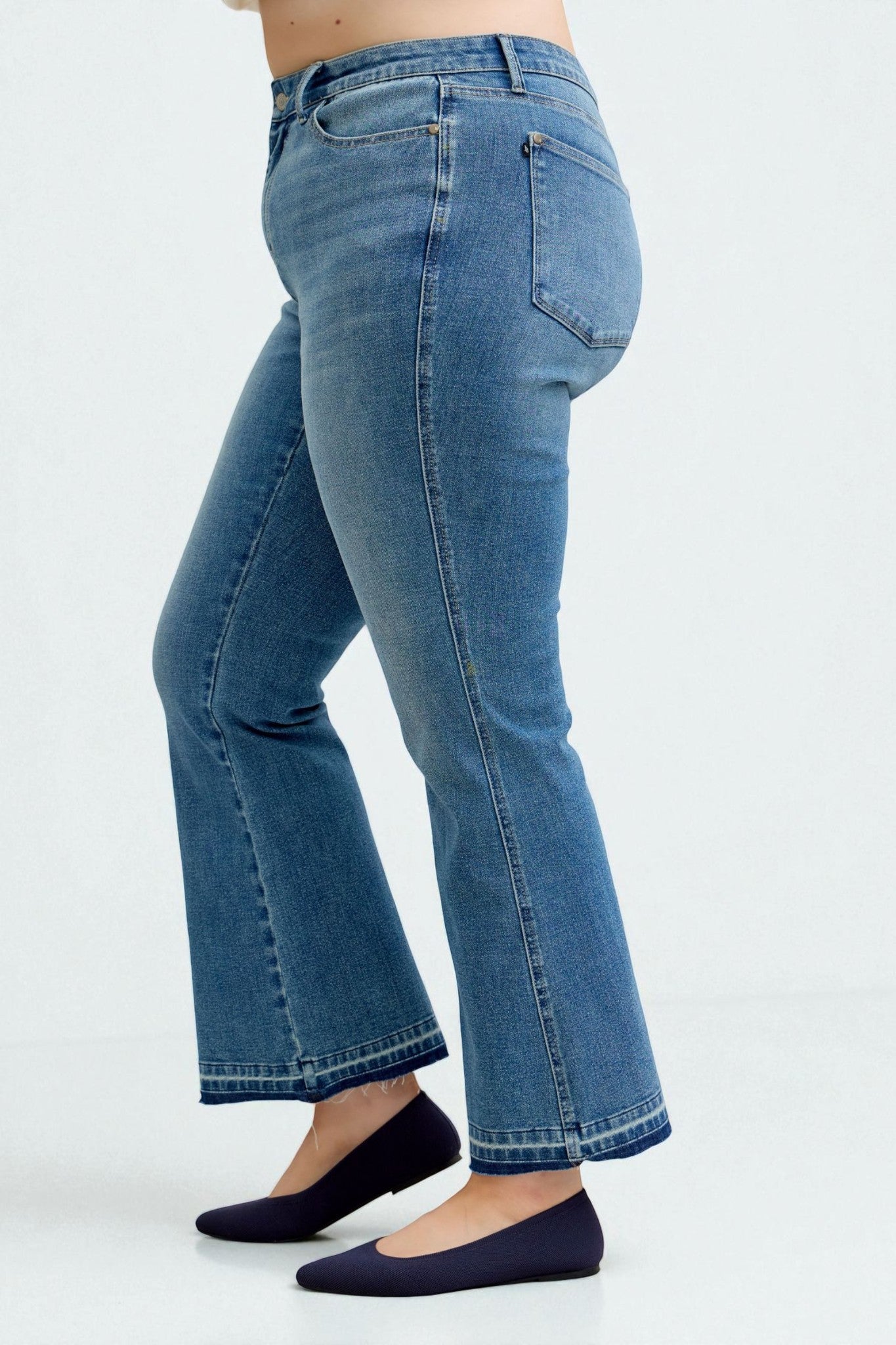 Blue jeans worn by a person on a white background