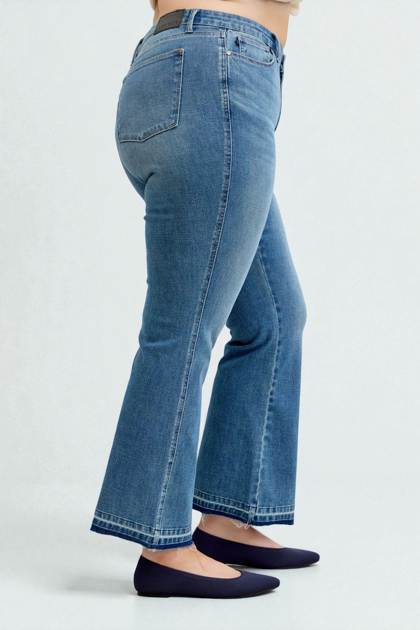 Blue jeans worn by a person on a white background