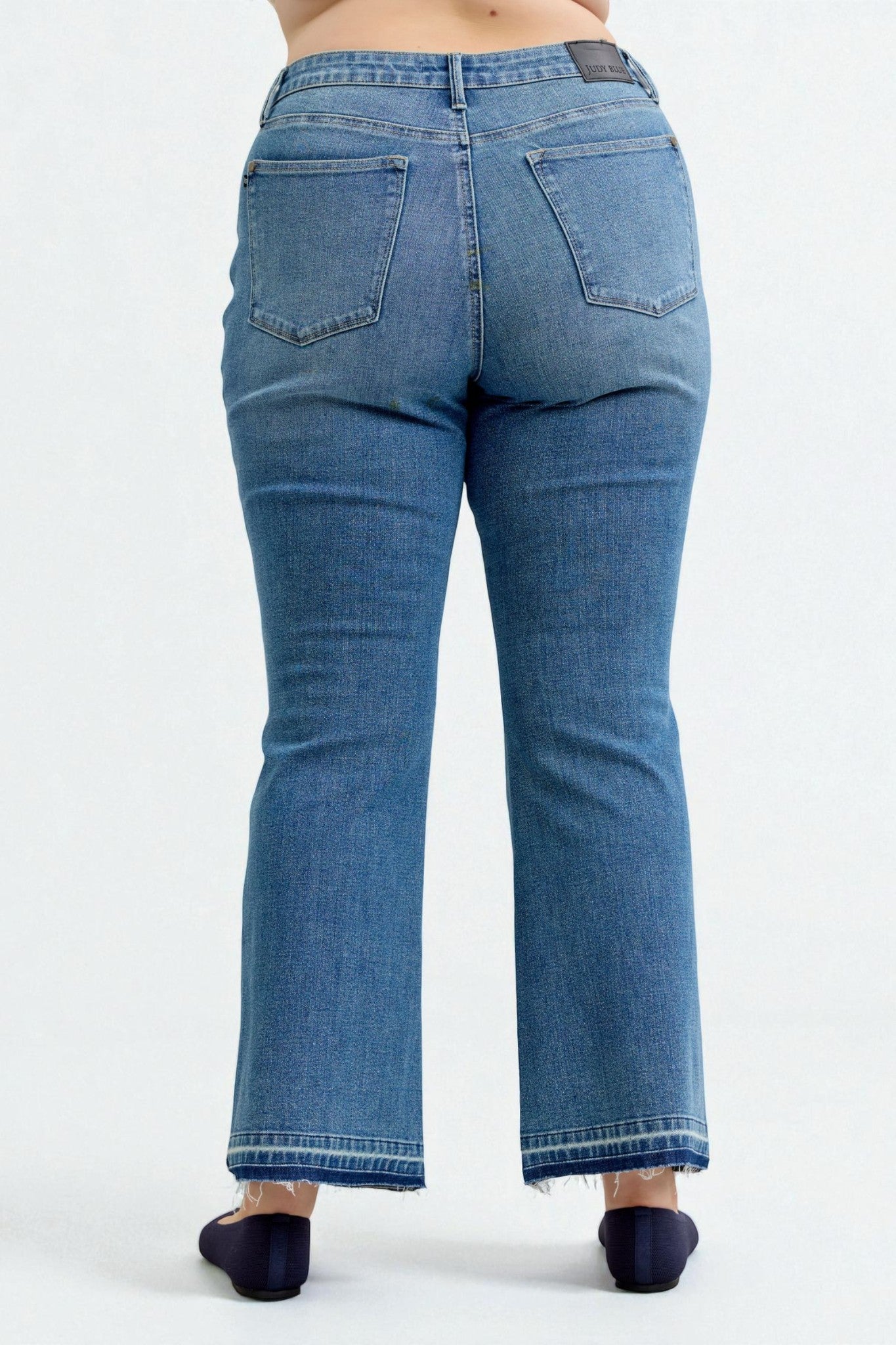 Blue jeans worn by a person on a white background
