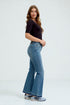 Woman wearing blue jeans and a black top on a white background