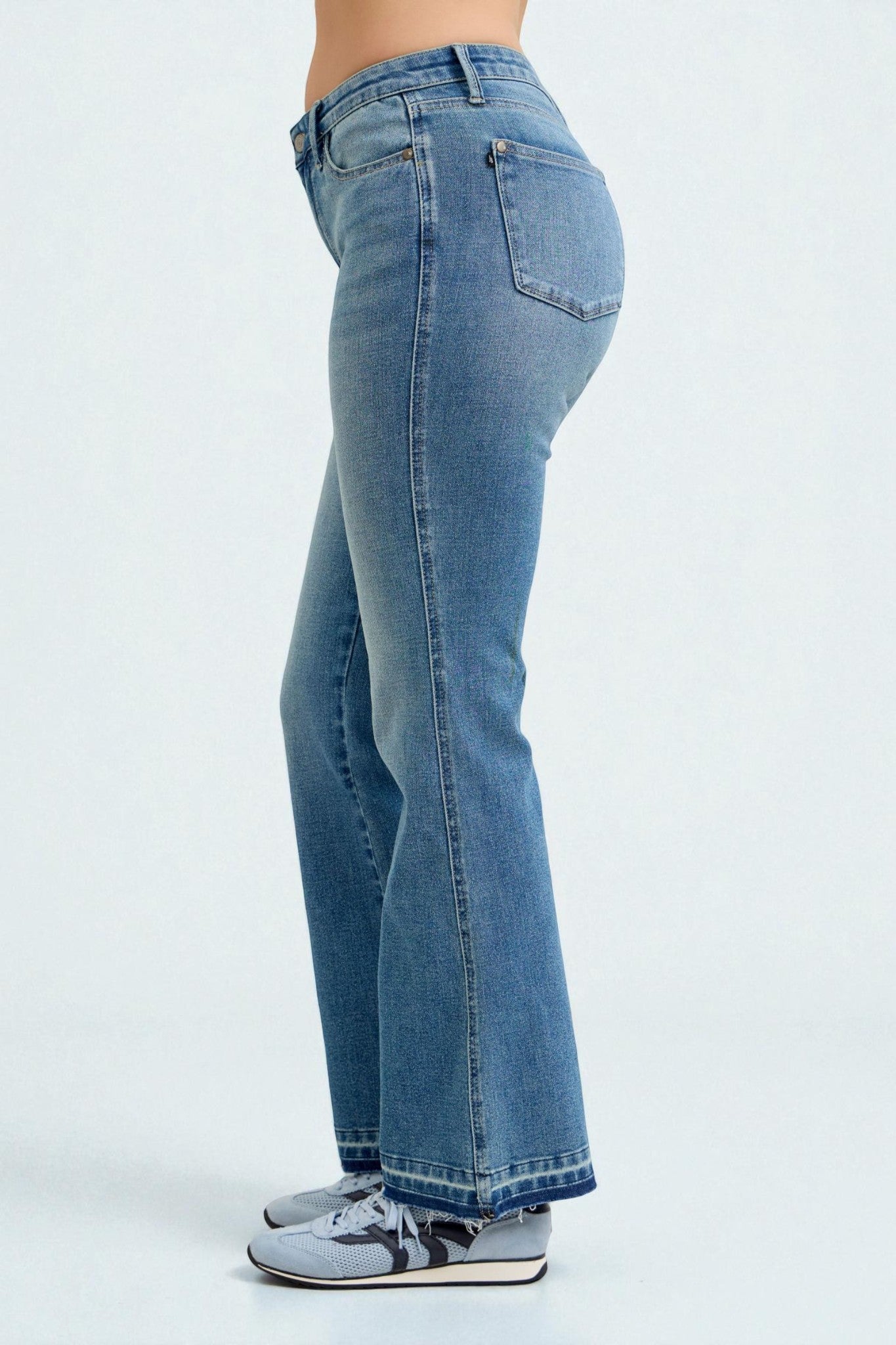 Blue jeans worn by a person on a white background