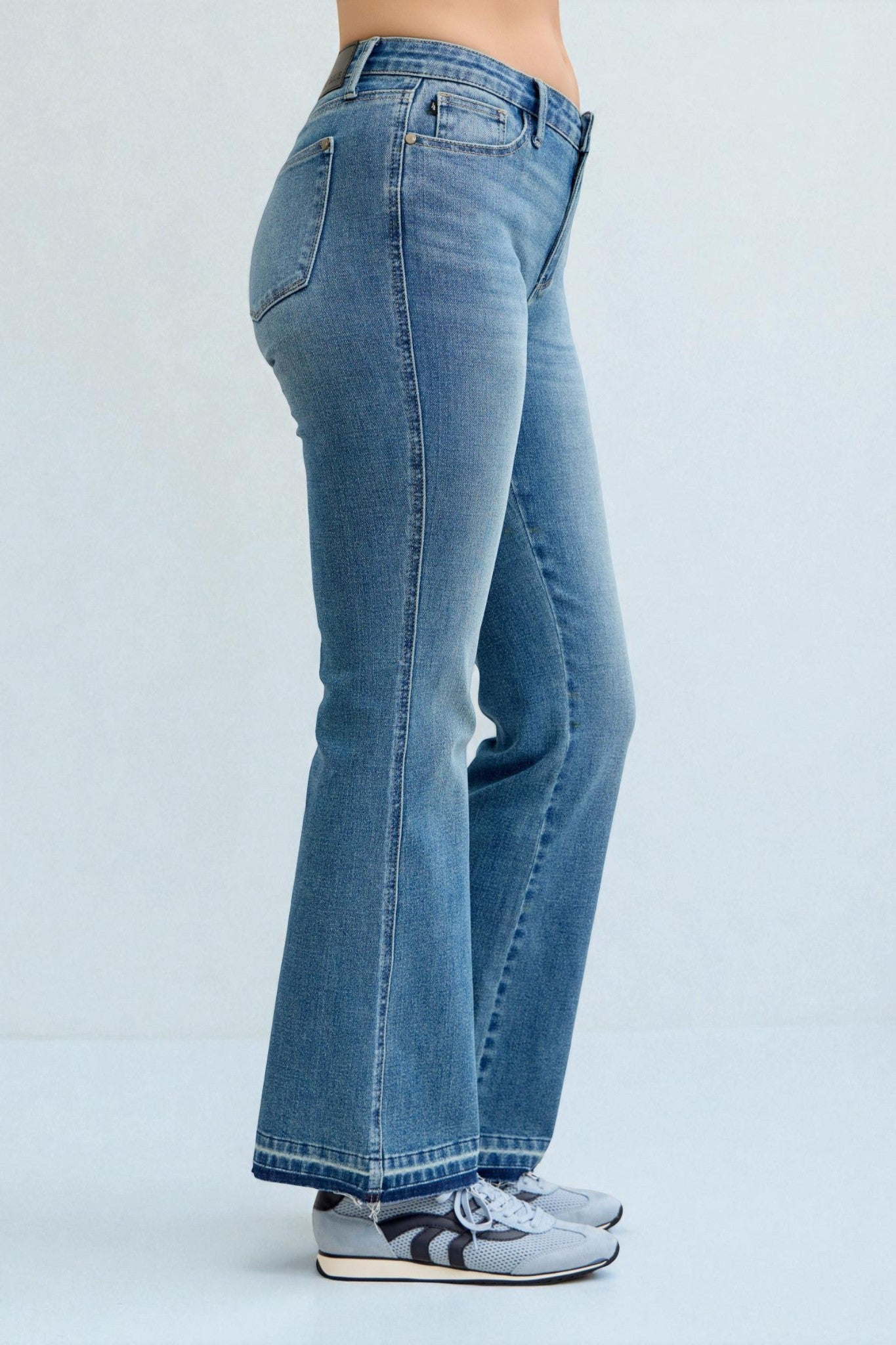 Blue jeans worn by a person on a light gray background