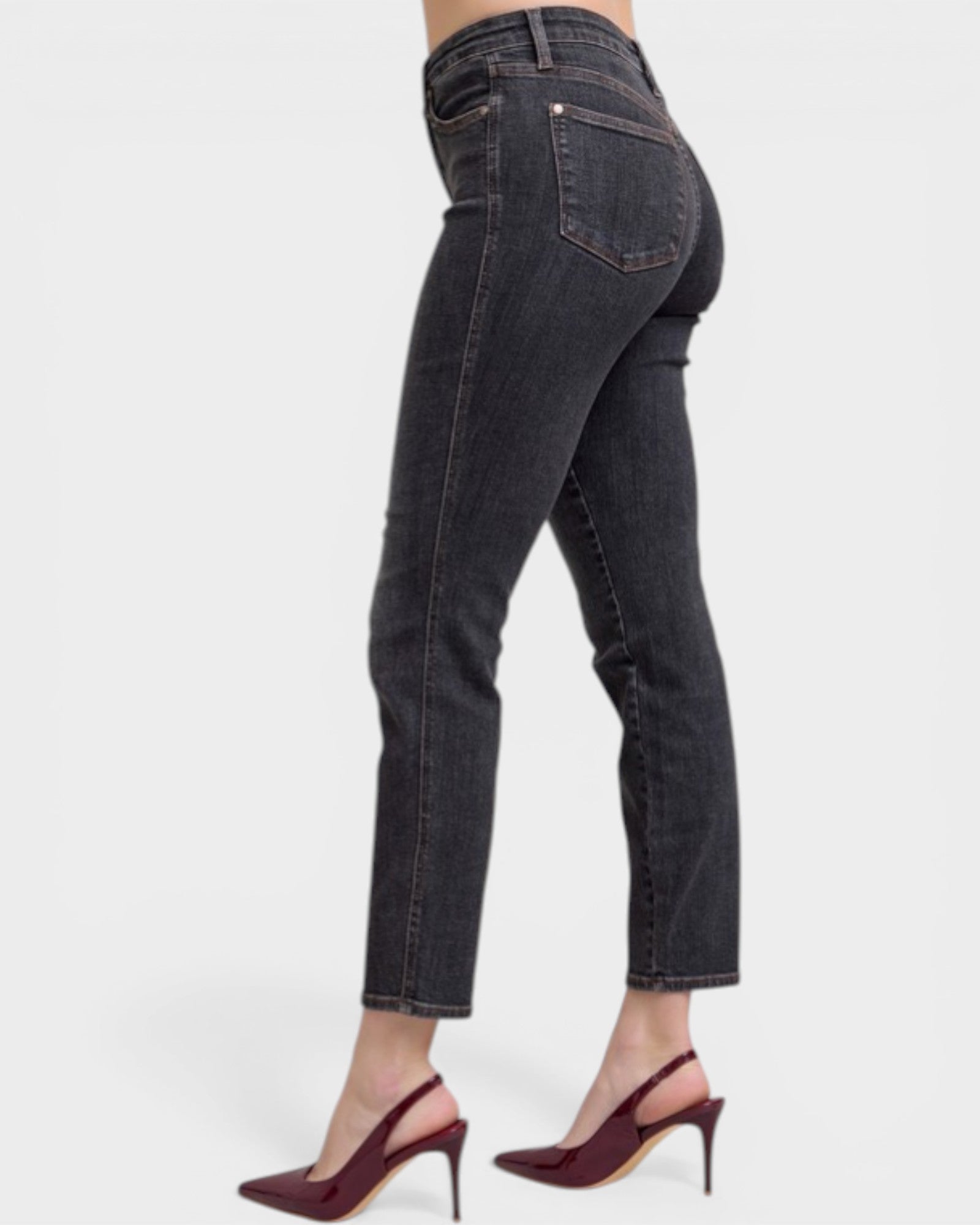 Black jeans worn by a person on a white background
