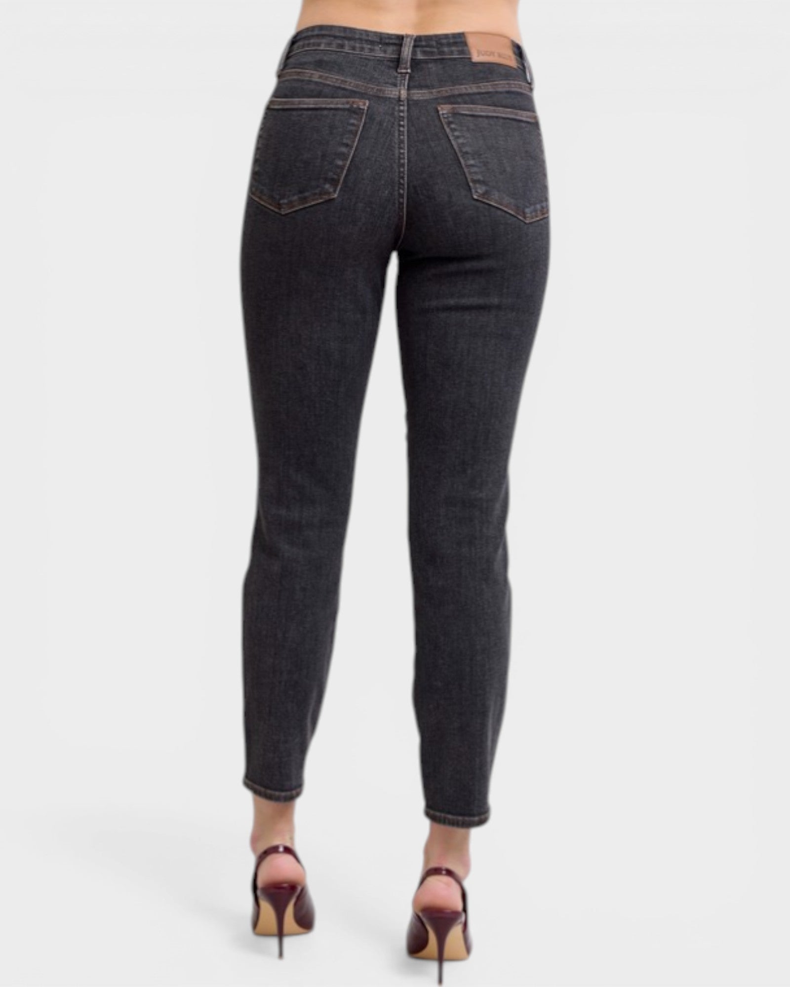Black jeans worn by a person on a white background