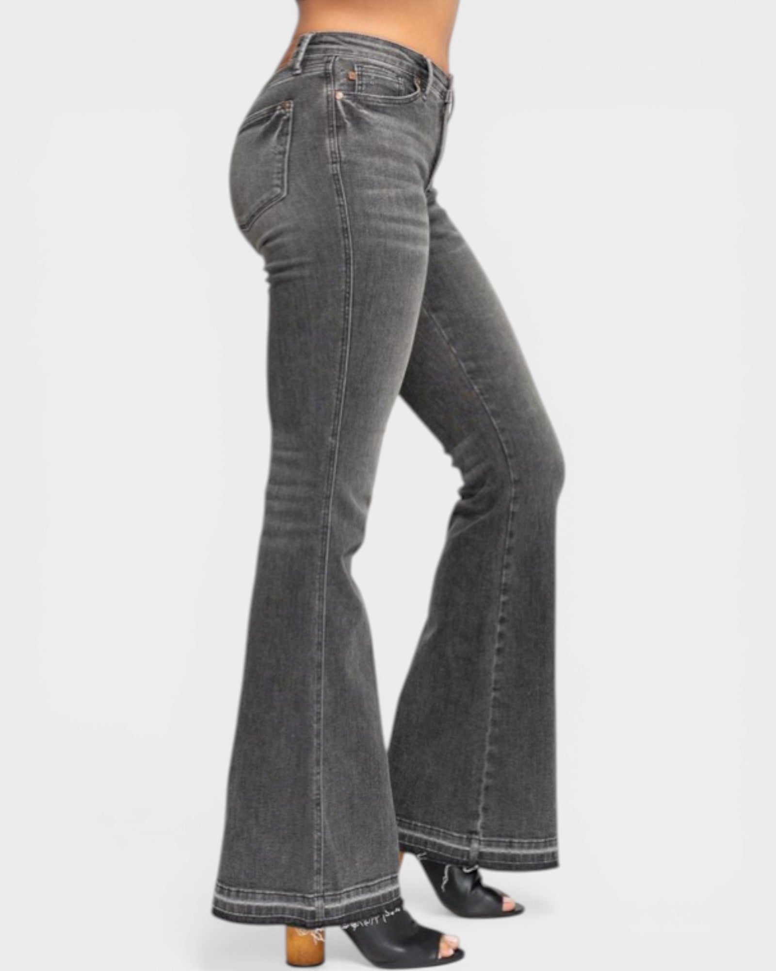 Gray flared jeans worn by a person on a white background