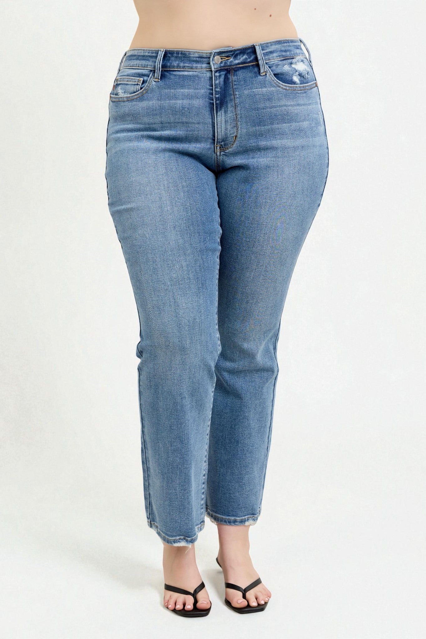 Blue jeans worn by a person on a white background