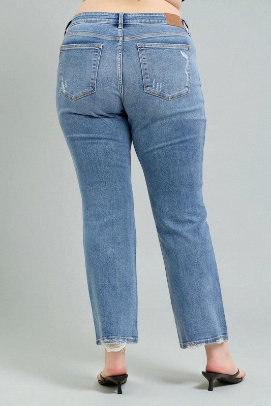 Person wearing blue jeans on a plain background