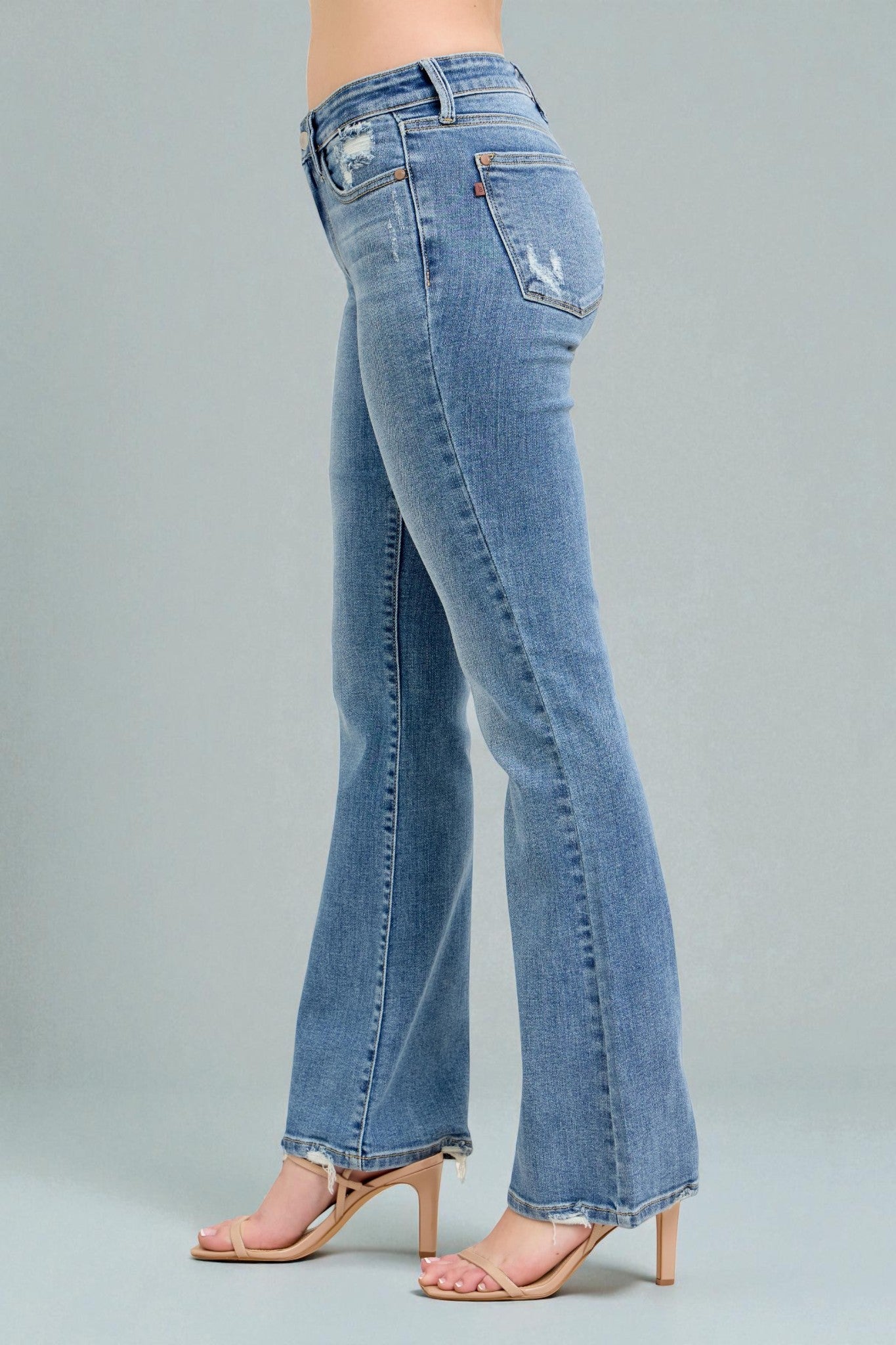 Blue jeans worn by a person on a gray background