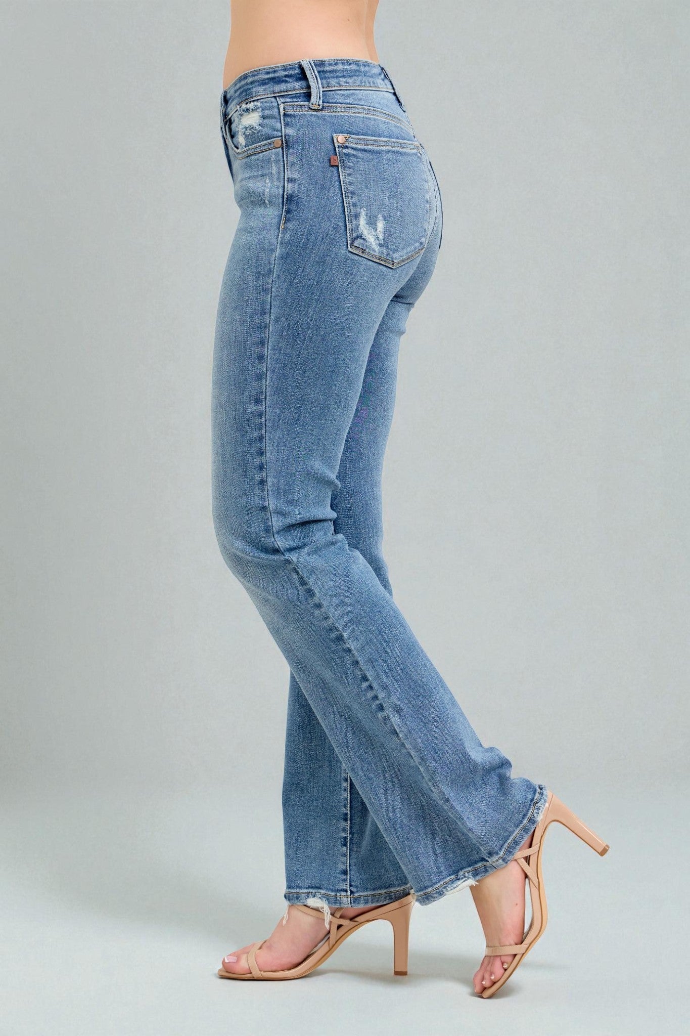 Blue jeans worn by a person on a gray background