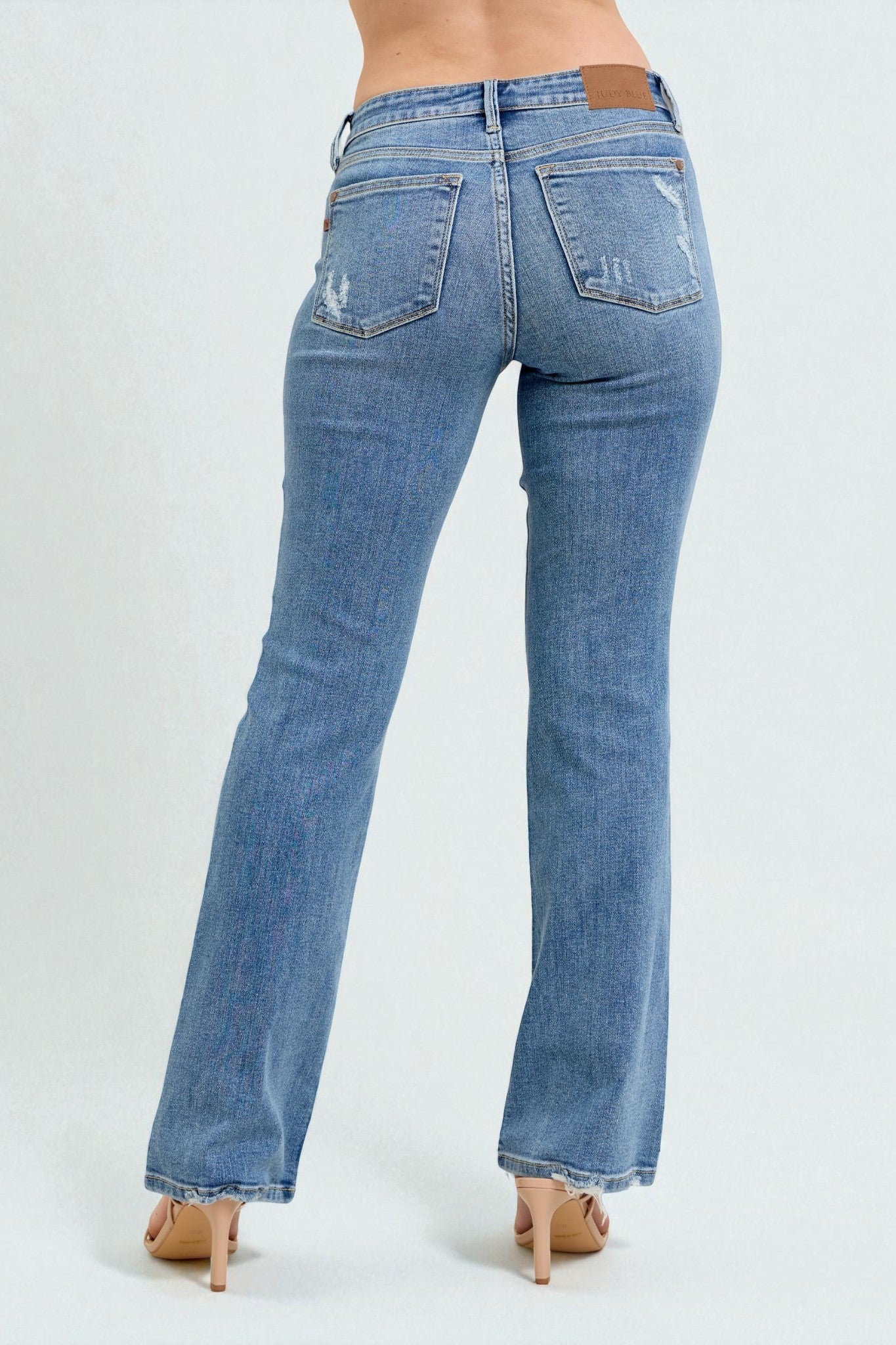 Blue jeans worn by a person on a white background