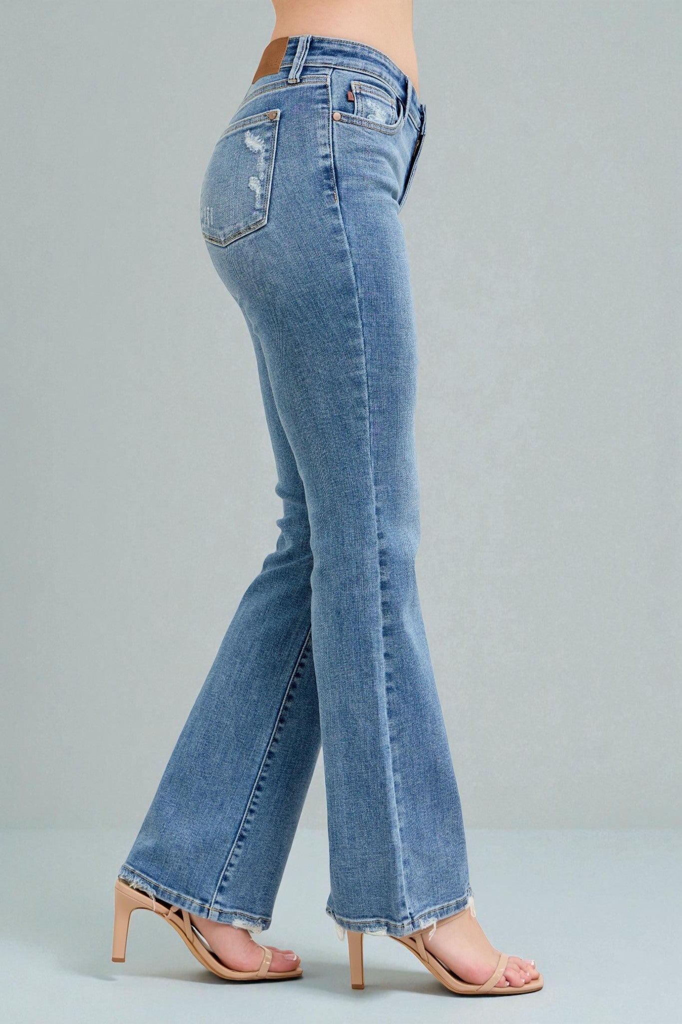 Blue jeans worn by a person on a gray background