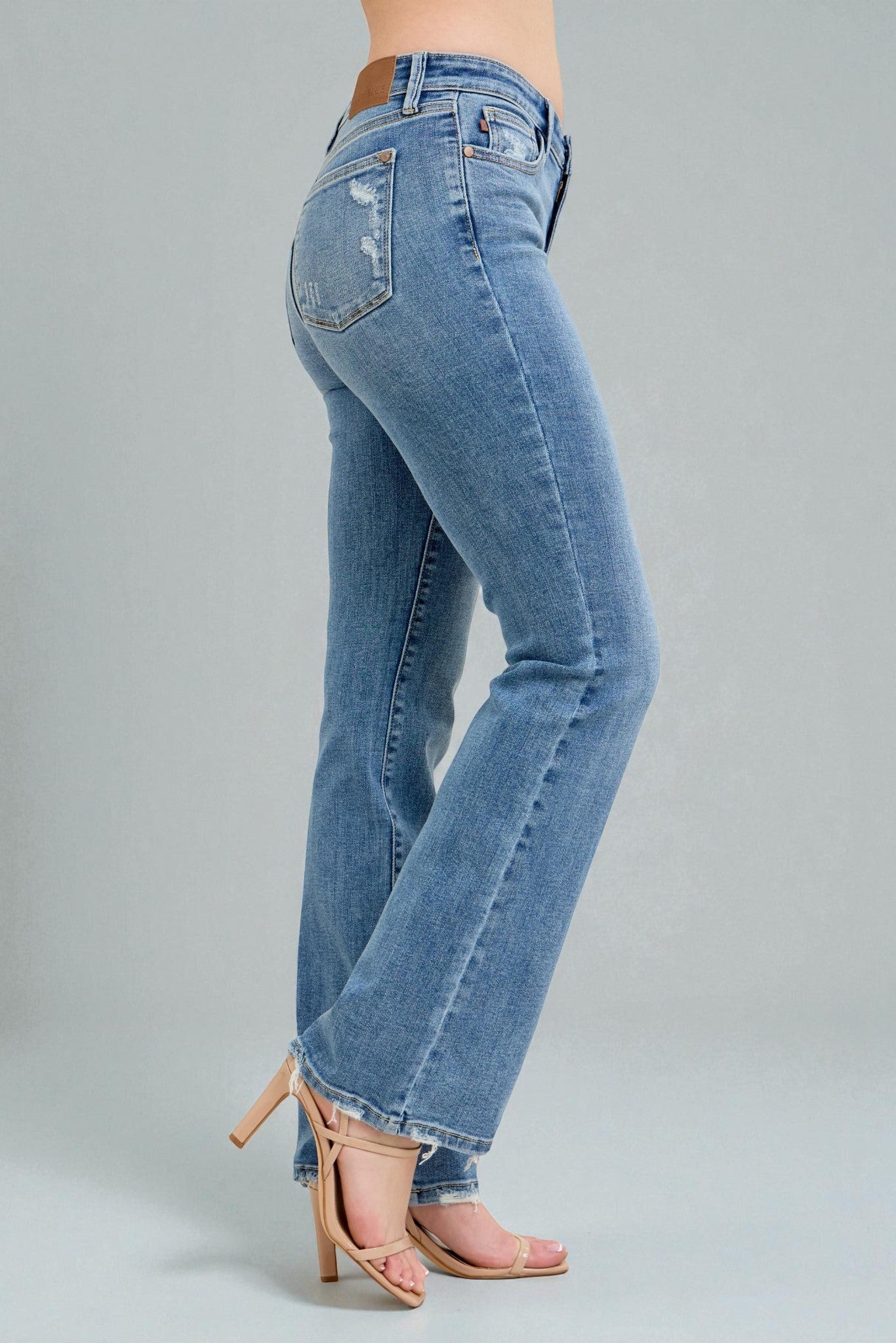 Blue jeans worn by a person on a gray background