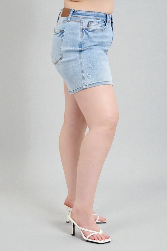 Light blue denim shorts worn by a person on a gray background