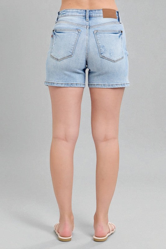 Light blue denim shorts worn by a person on a gray background
