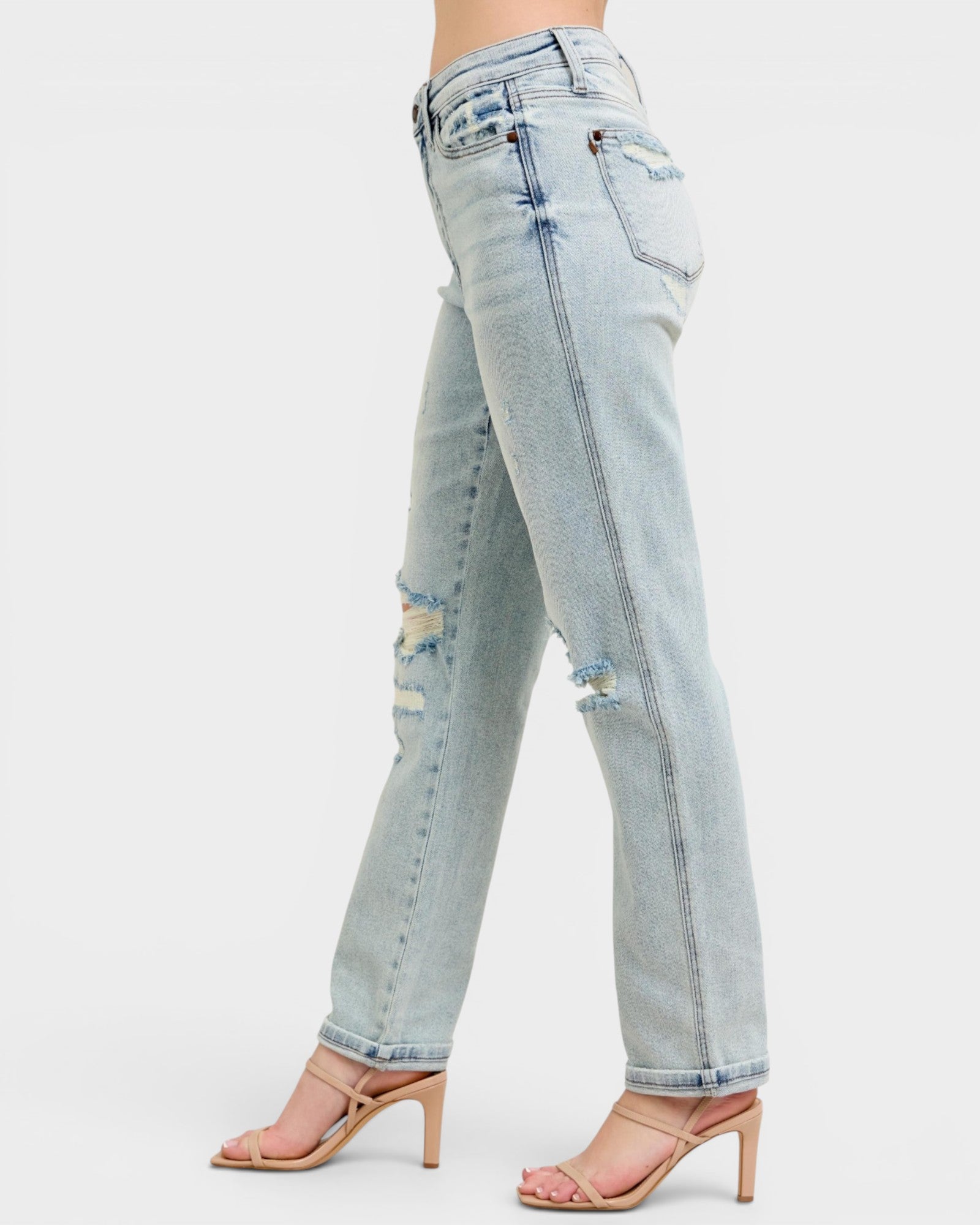 Light blue distressed jeans worn by a person on a white background