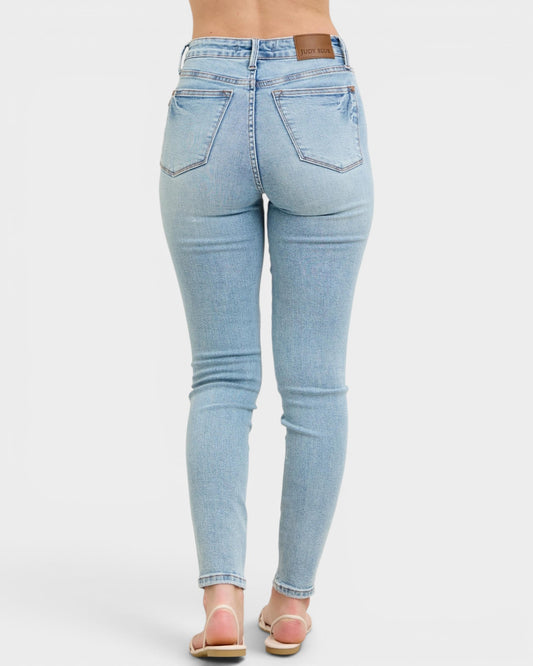 Light blue jeans worn by a person on a white background