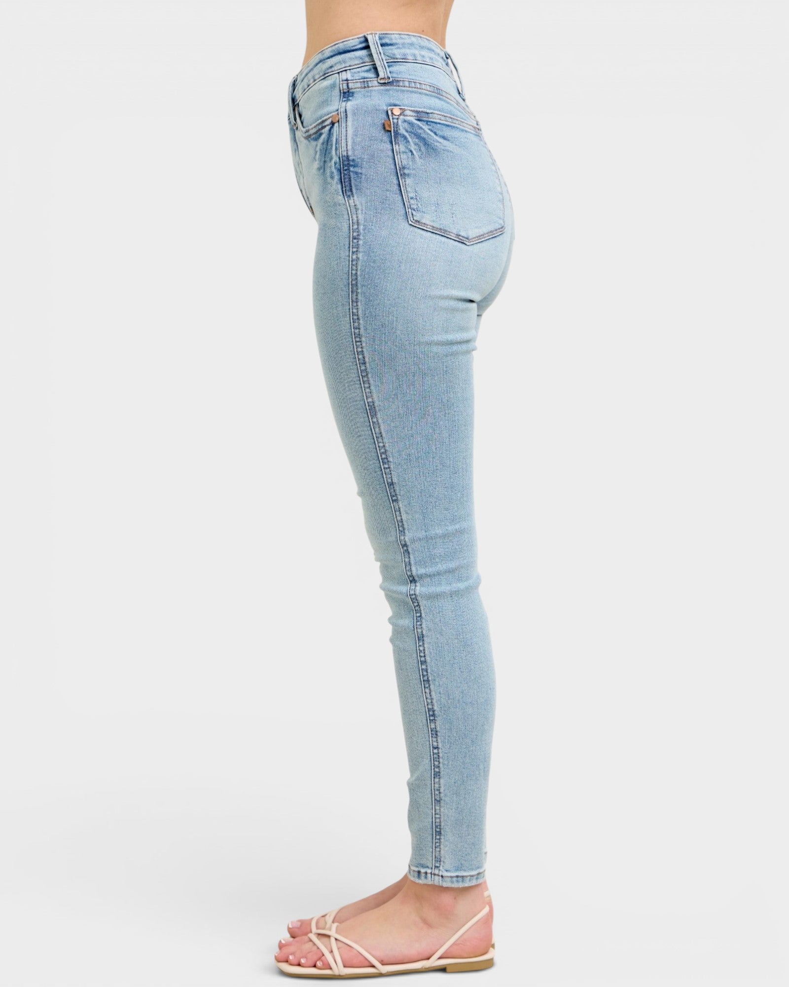 Light blue jeans worn by a person on a white background