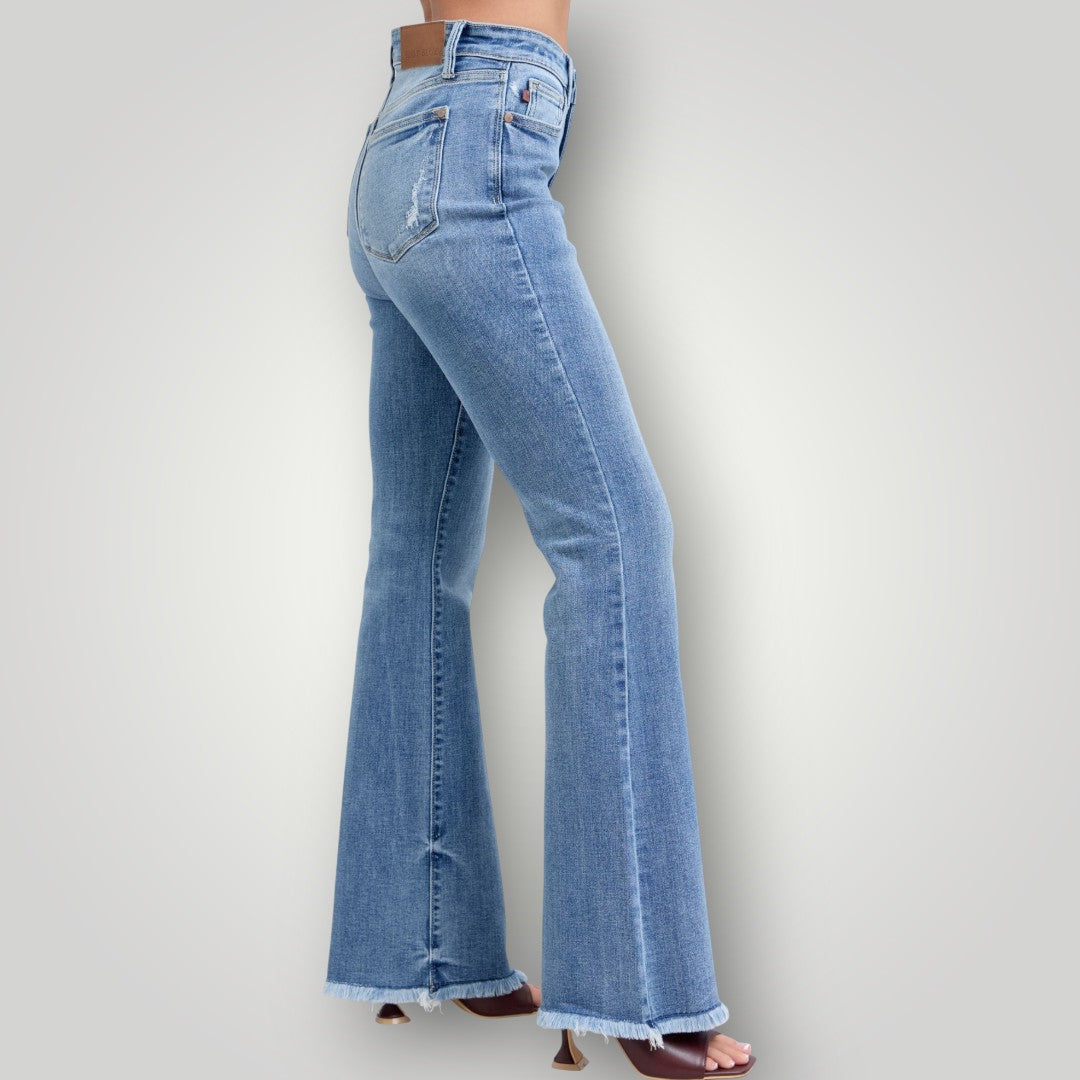 Light blue flared jeans worn by a person on a plain background