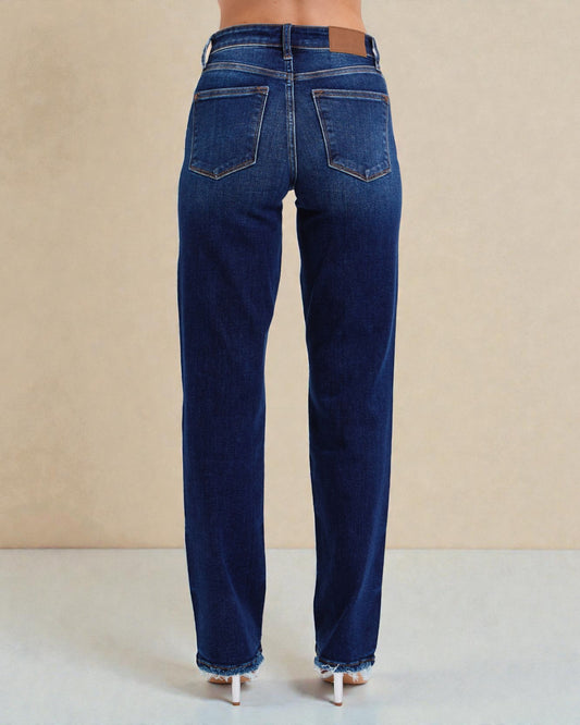 Blue jeans worn by a person on a beige background