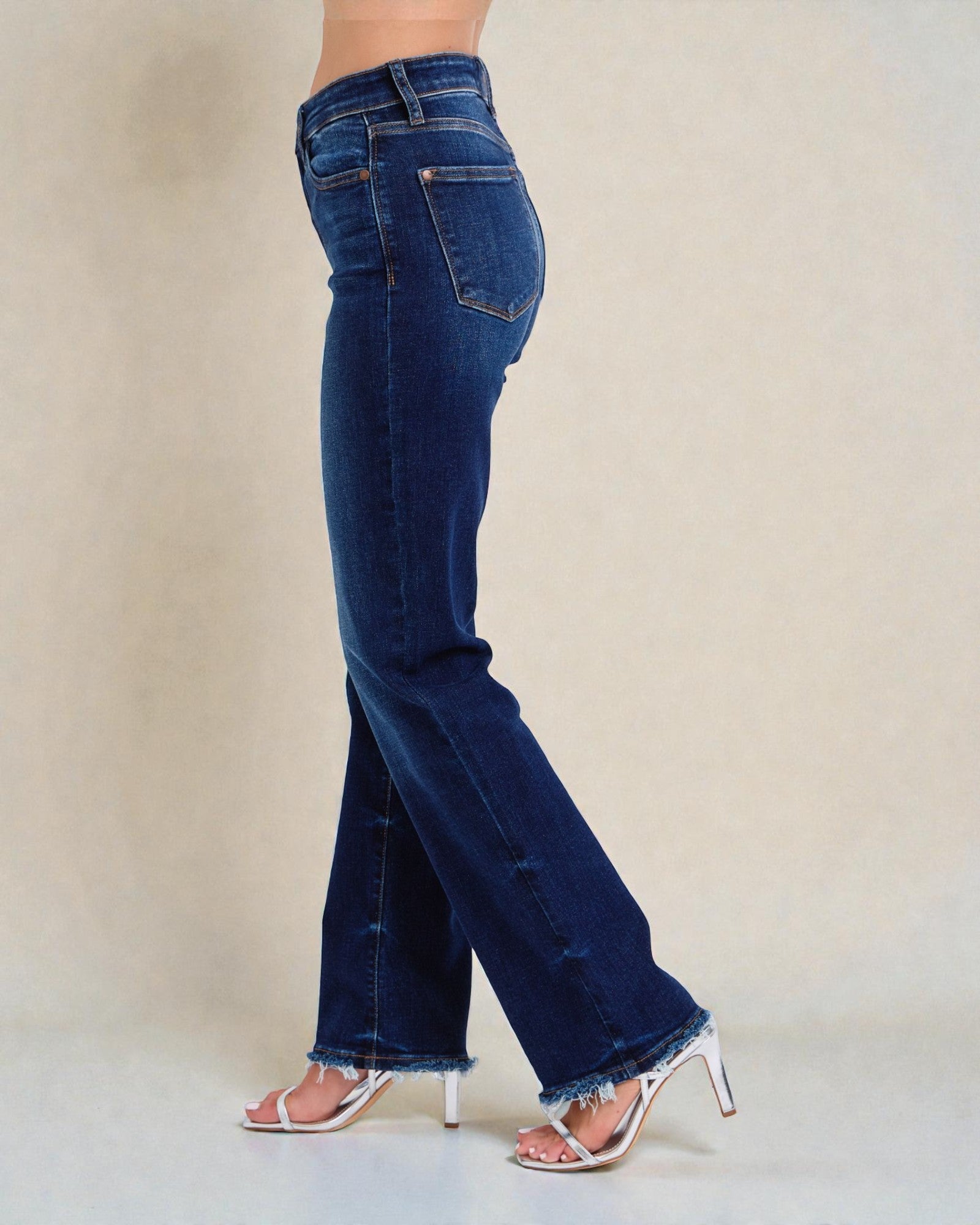 Blue jeans worn by a person on a neutral background