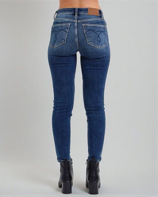 Blue jeans worn by a person on a gray background