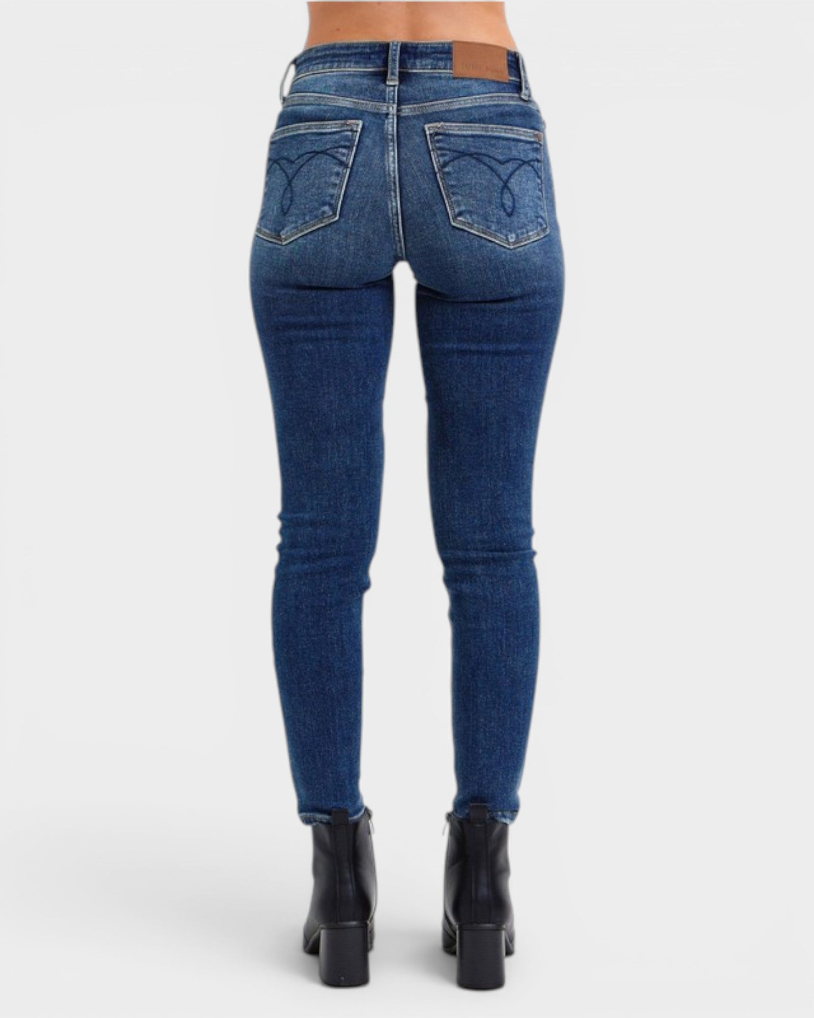 Blue jeans worn by a person on a white background