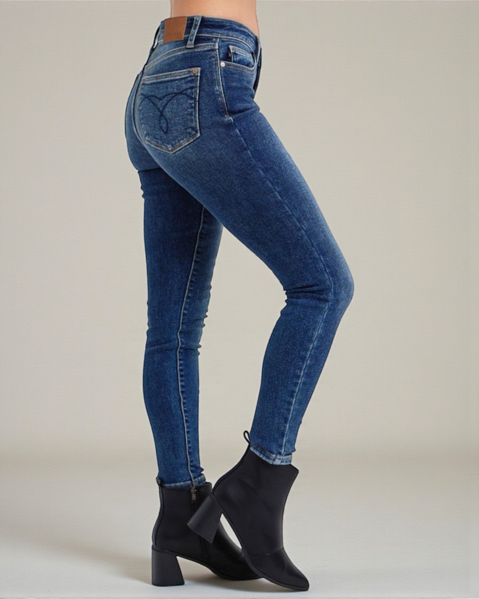 Blue jeans worn by a person on a neutral background