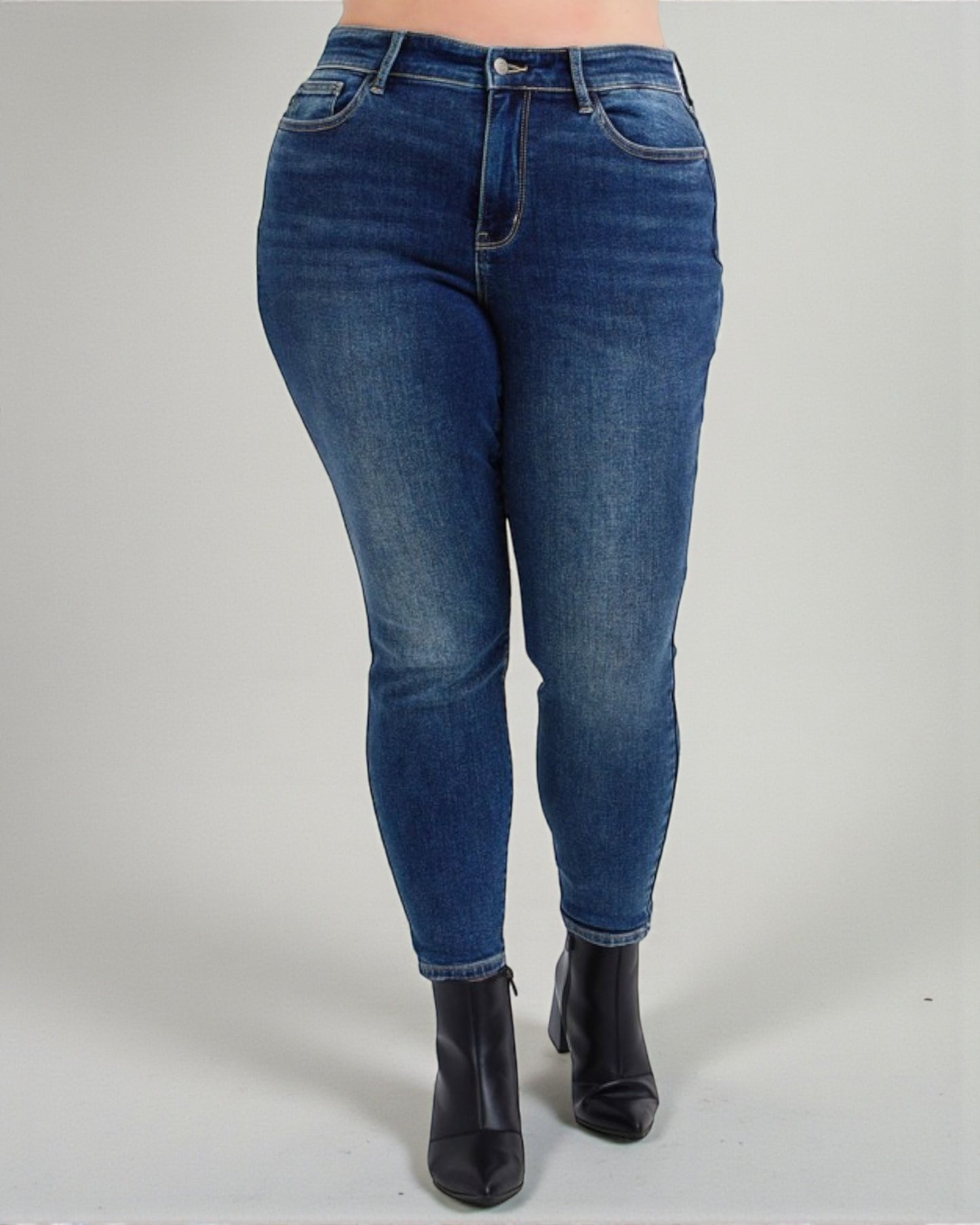Blue jeans worn by a person on a gray background