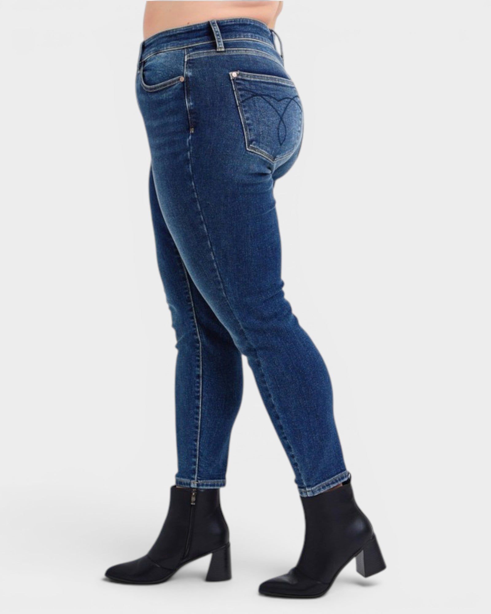 Blue jeans worn by a person on a white background