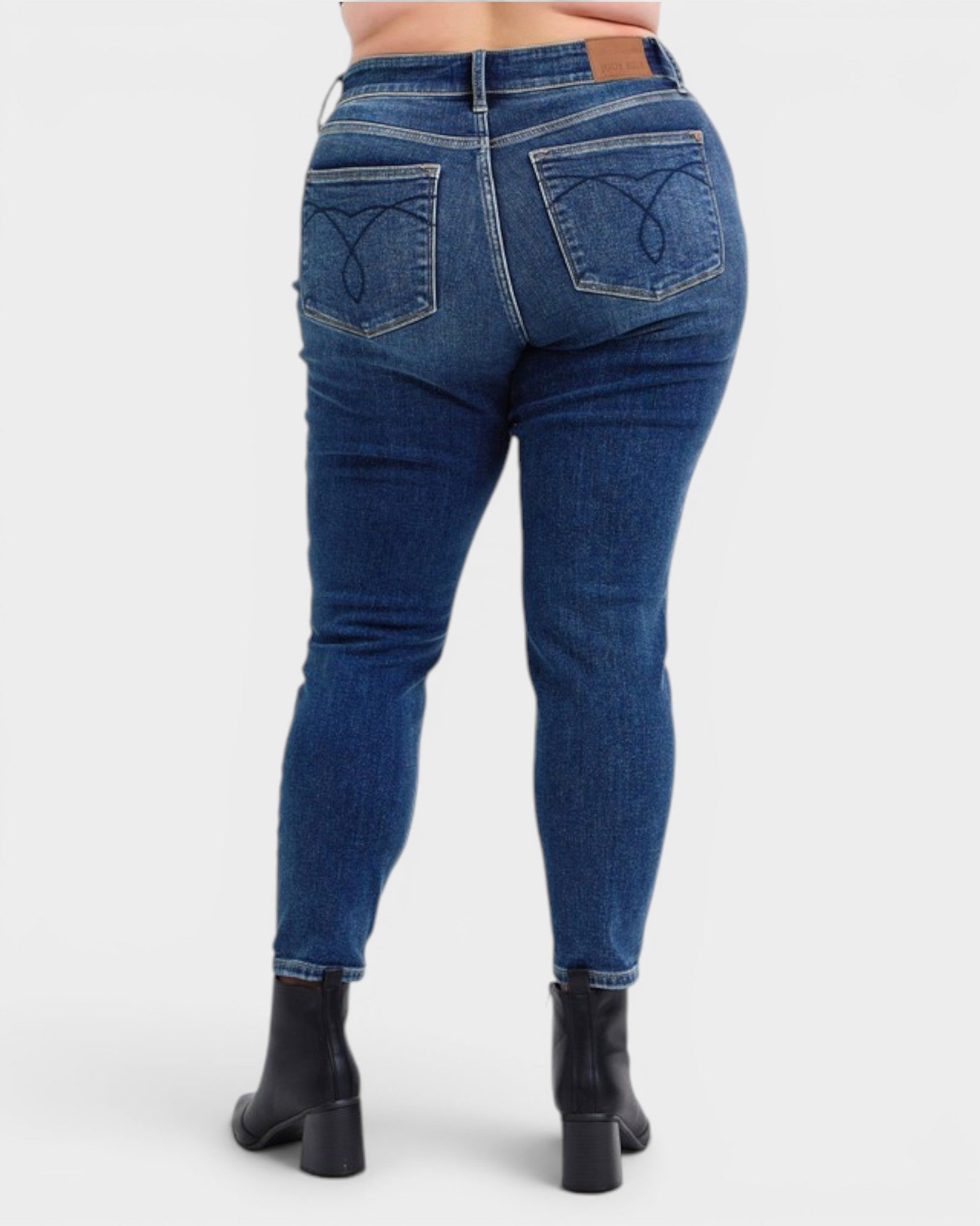 Blue jeans worn by a person on a white background