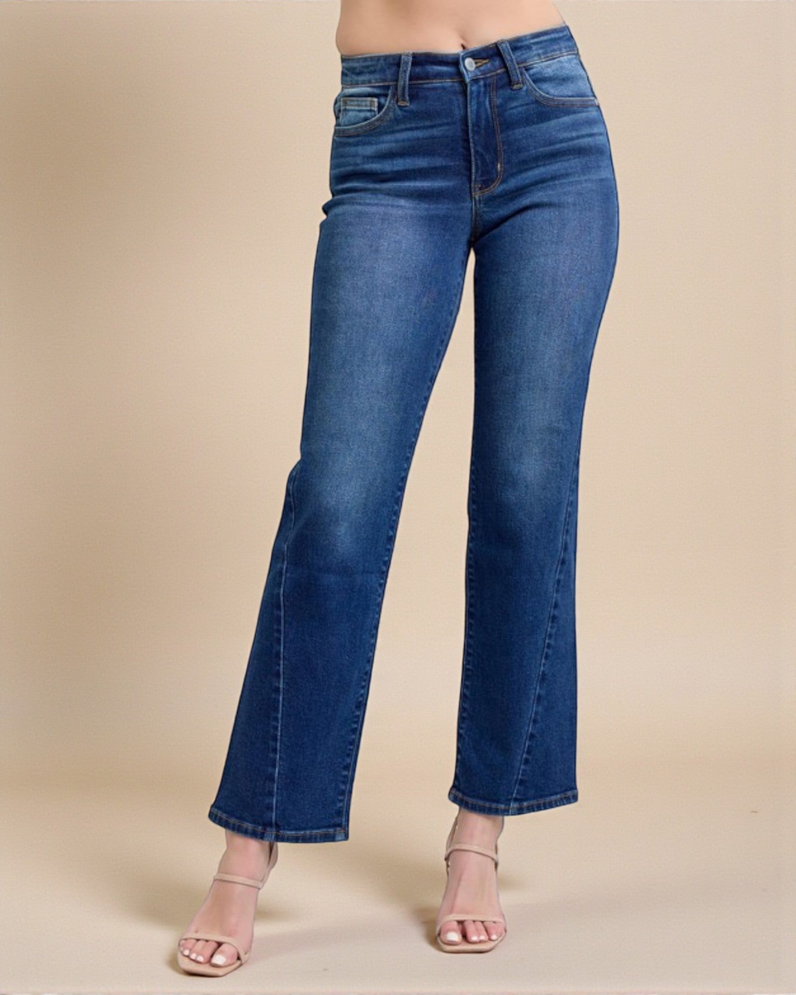 Blue jeans worn by a person on a beige background