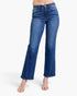 A model wearing a pair of medium-wash blue denim flare jeans with a straight-to-slightly-flared leg, paired with nude heeled sandals against a plain white background.