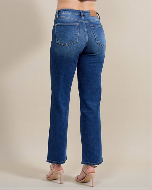 Blue jeans worn by a person on a beige background