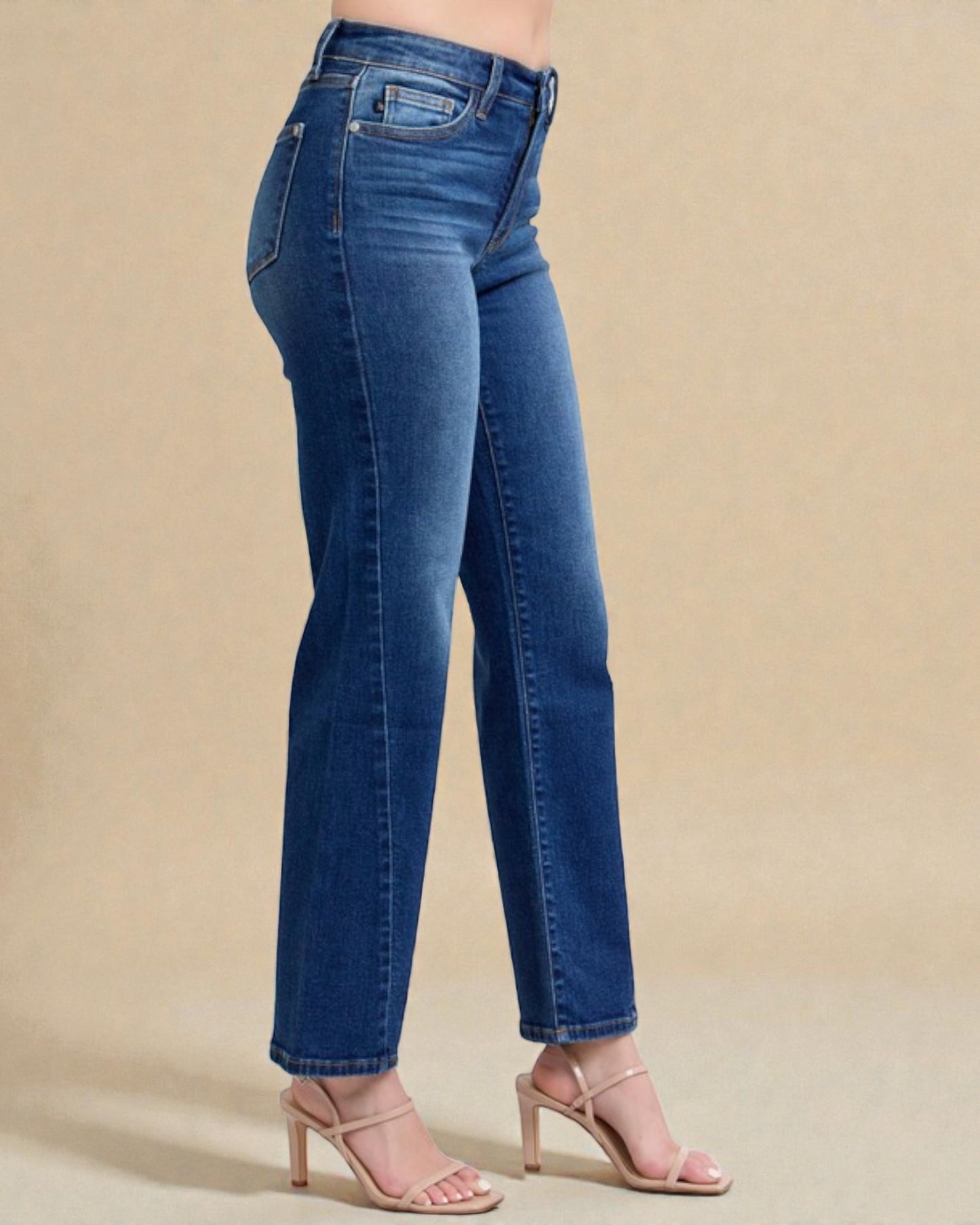 Blue jeans worn by a person on a beige background