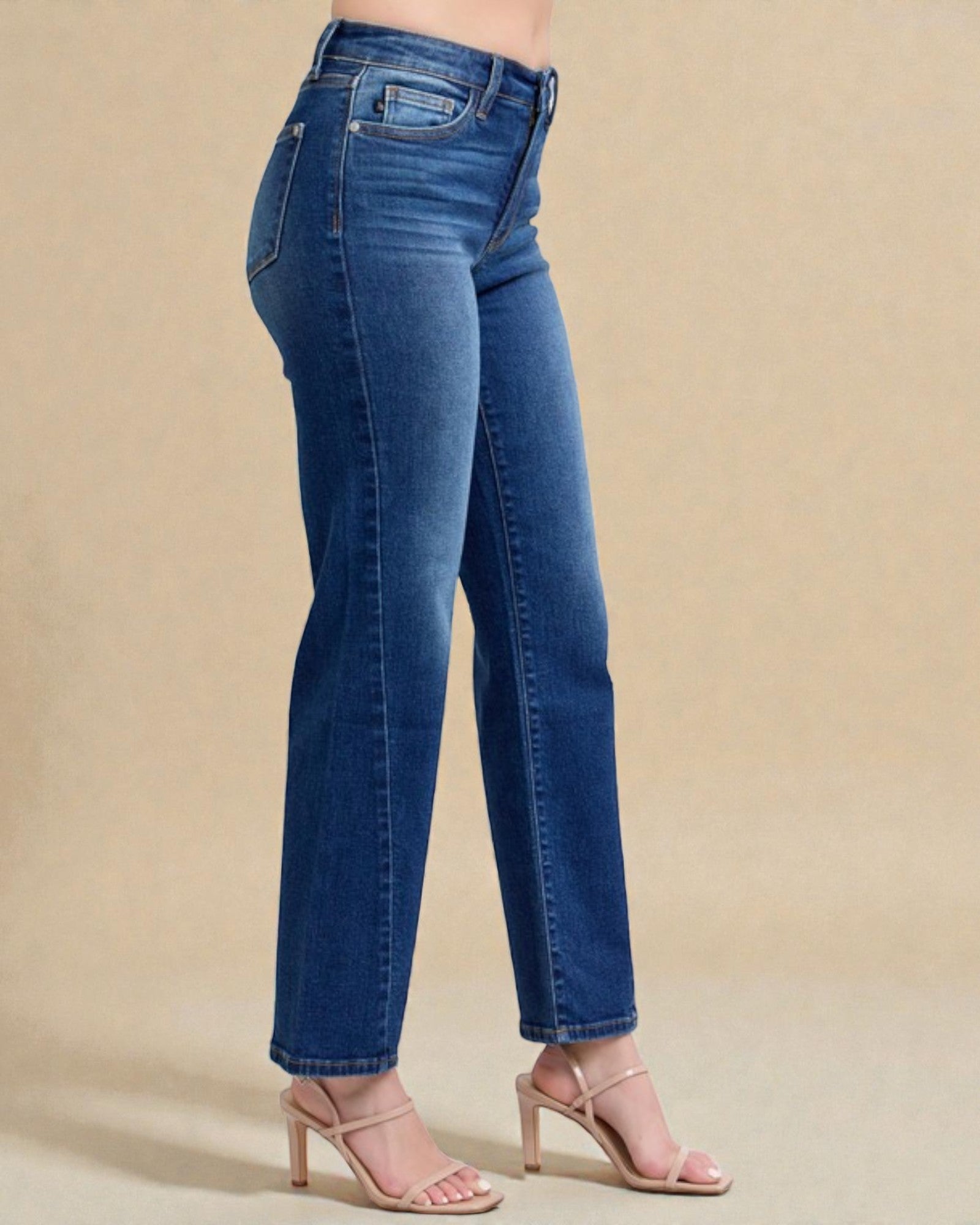 Blue jeans worn by a person on a beige background