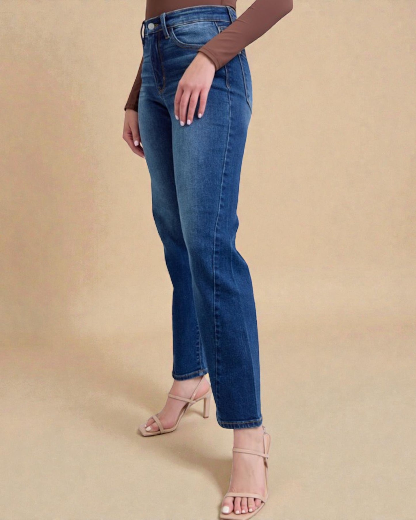 Person wearing blue jeans on a beige background