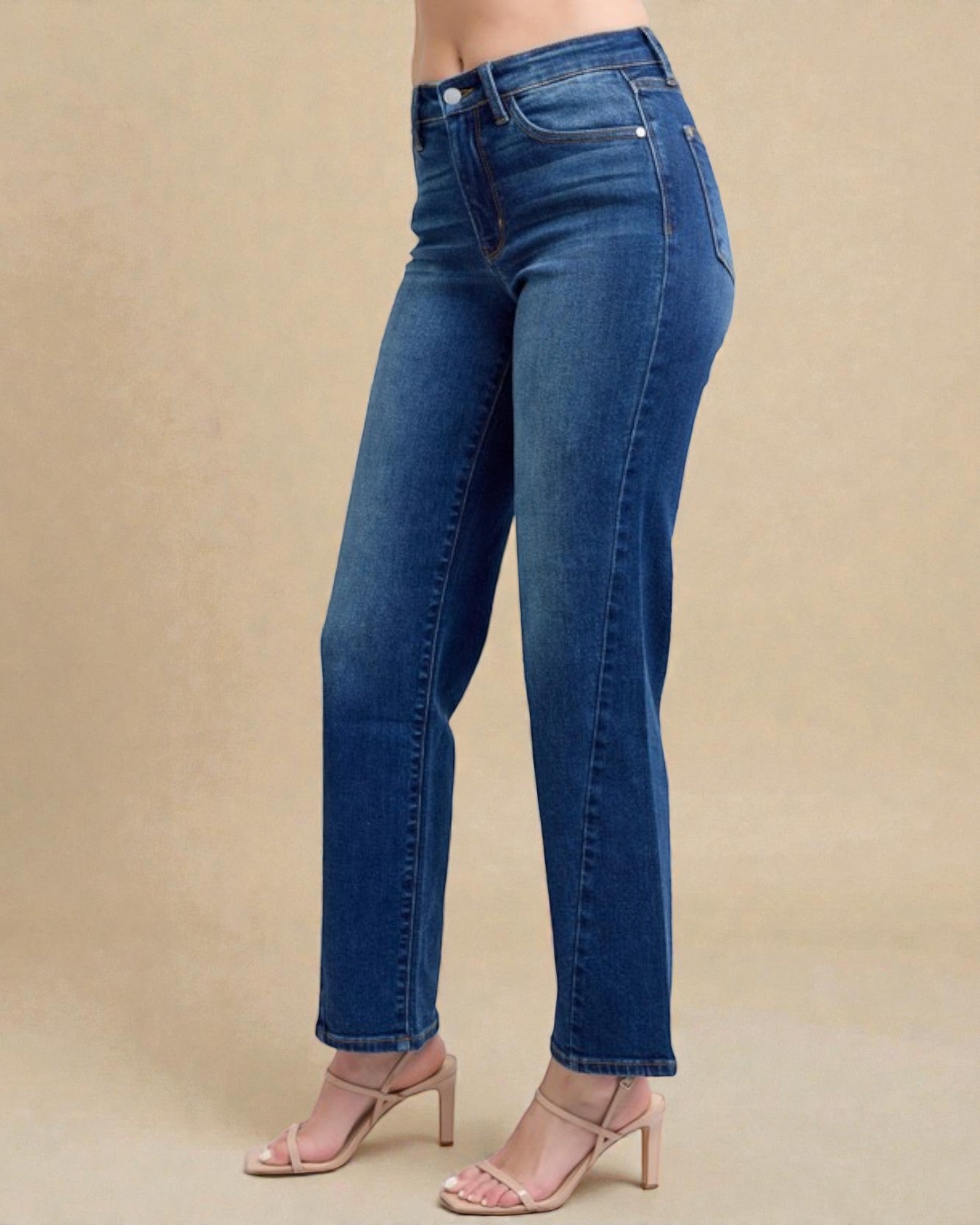 Blue jeans worn by a person on a beige background