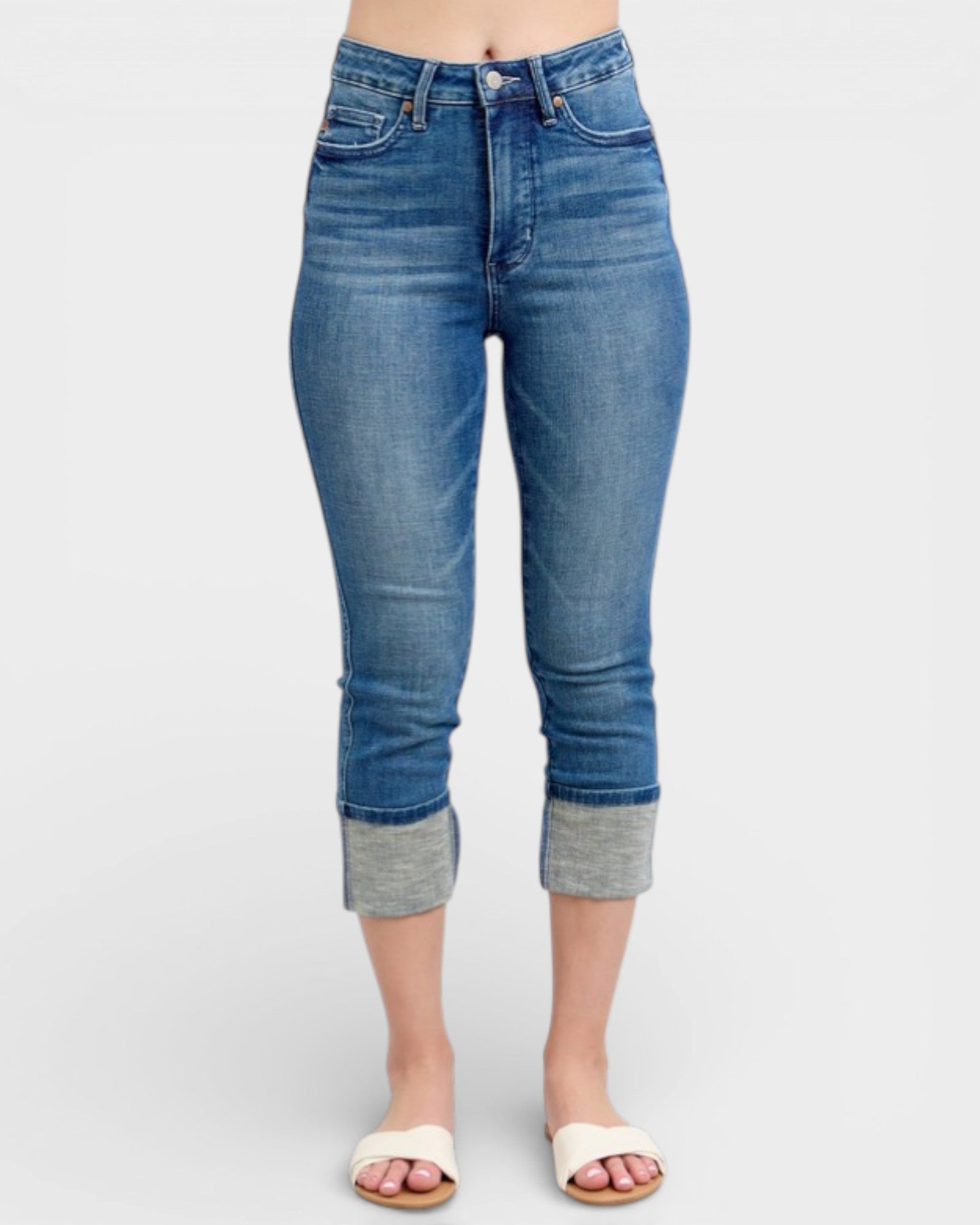 Blue jeans with rolled-up cuffs on a white background