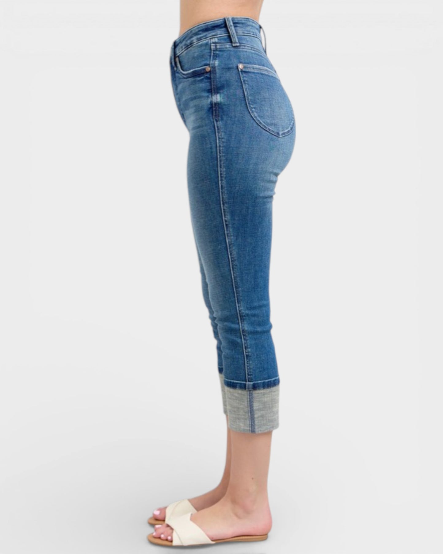 Blue jeans worn by a person on a white background