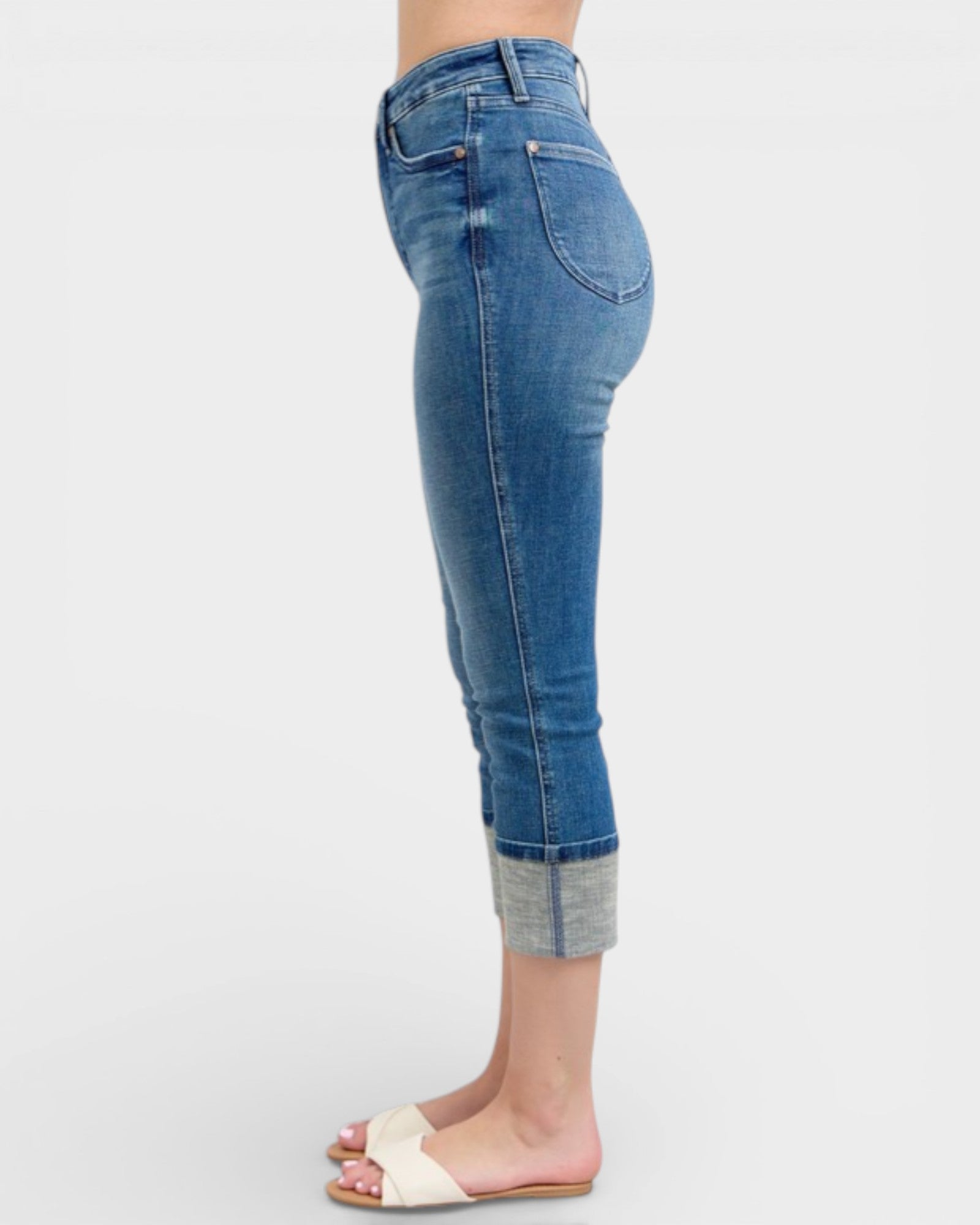 Blue jeans worn by a person on a white background